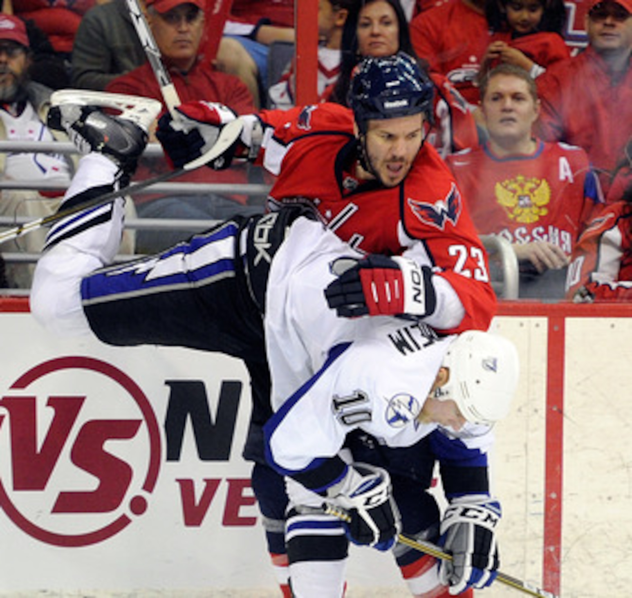 WASHINGTON, DC - APRIL 29:  Scott Hannan #23 of the Washington Capitals collides with Sean Bergenheim #10 of the Tampa Bay Lightning during Game One of the Eastern Conference Semifinal during the 2011 NHL Stanley Cup Finals at the Verizon Center on April