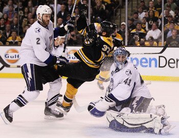 BOSTON, MA - MAY 23:  Eric Brewer #2 of the Tampa Bay Lightning checks Patrice Bergeron #37 of the Boston Bruins as Mike Smith #41 of the Tampa Bay Lightning looks on in Game Five of the Eastern Conference Finals during the 2011 NHL Stanley Cup Playoffs a