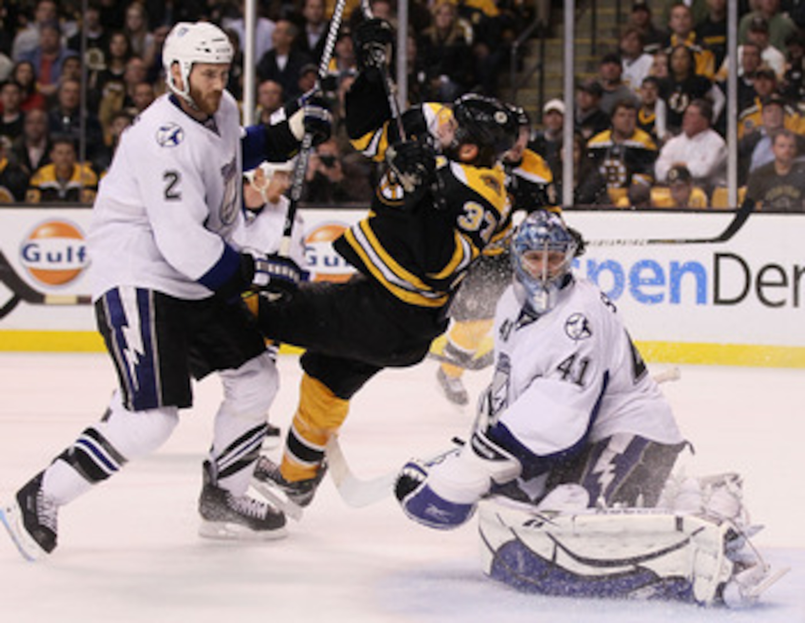 BOSTON, MA - MAY 23:  Eric Brewer #2 of the Tampa Bay Lightning checks Patrice Bergeron #37 of the Boston Bruins as Mike Smith #41 of the Tampa Bay Lightning looks on in Game Five of the Eastern Conference Finals during the 2011 NHL Stanley Cup Playoffs a