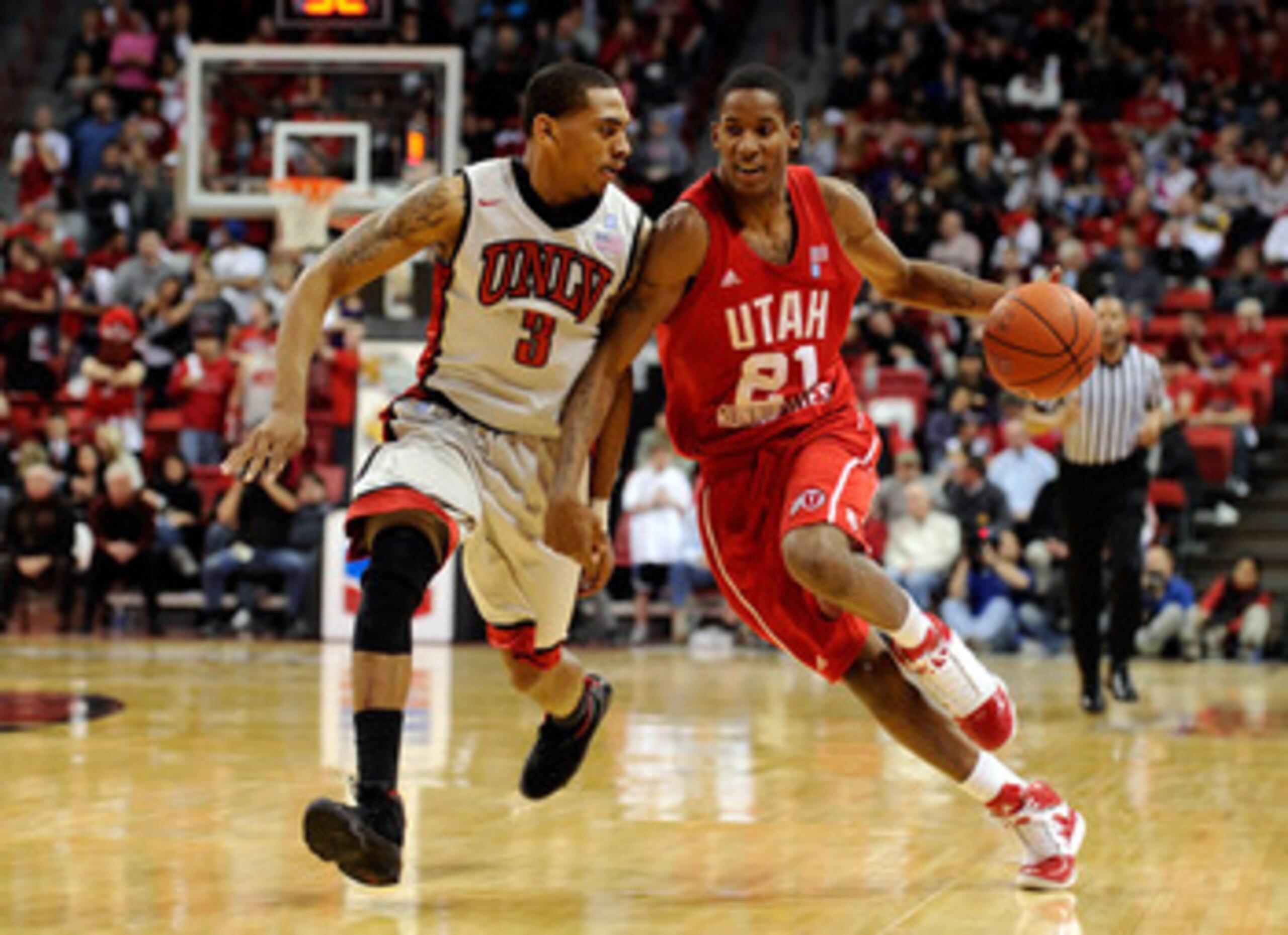 LAS VEGAS, NV - FEBRUARY 02:  Will Clyburn #21 of the Utah Utes drives against Anthony Marshall #3 of the UNLV Rebels during their game at the Thomas & Mack Center February 2, 2011 in Las Vegas, Nevada. UNLV won 67-54.  (Photo by Ethan Miller/Getty Images