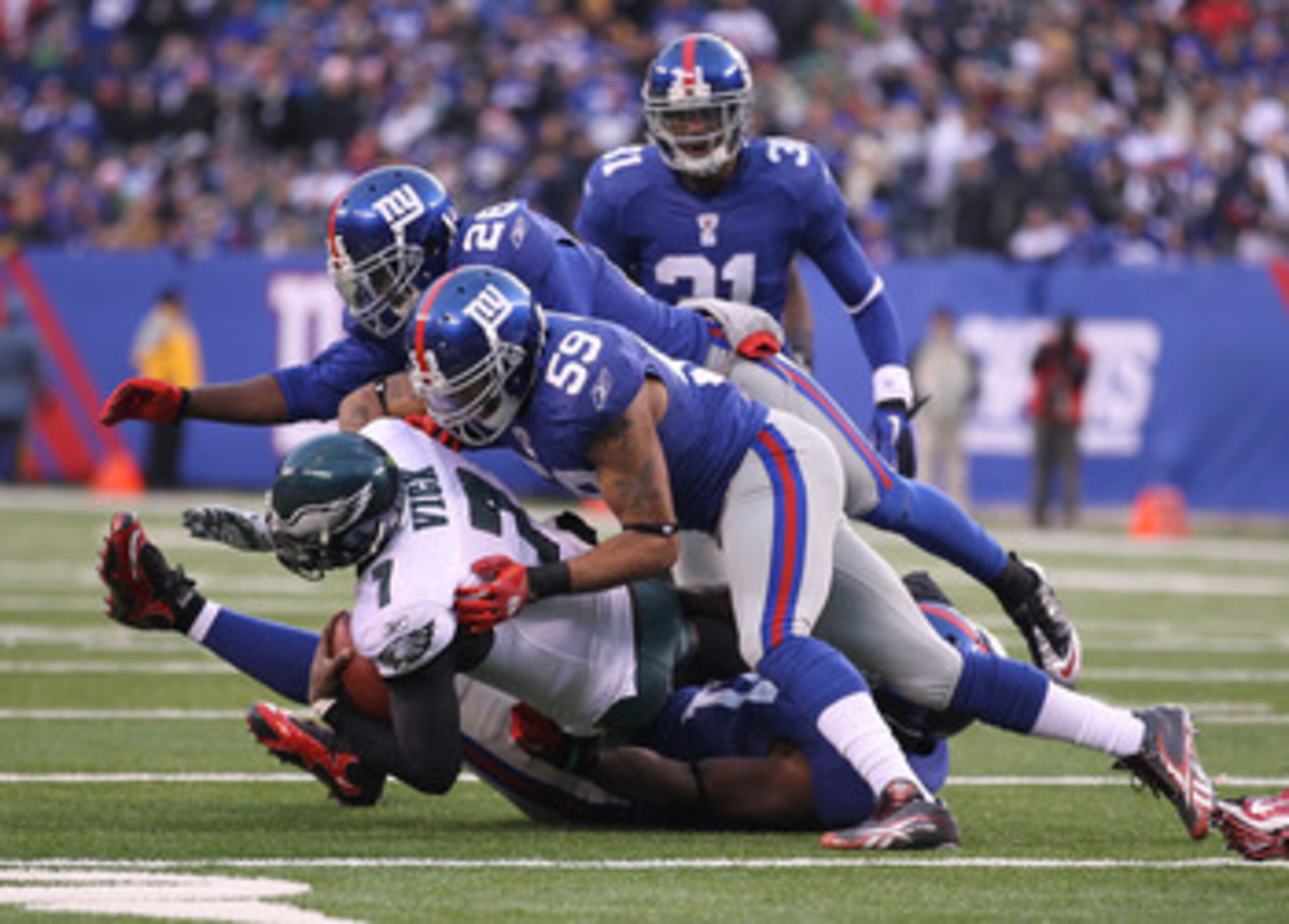 EAST RUTHERFORD, NJ - DECEMBER 19: Justin Tuck #91, Michael Boley #59, and Antrel Rolle #26 of the New York Giants tackle Michael Vick #7 of the Philadelphia Eagles during their game on December 19, 2010 at The New Meadowlands Stadium in East Rutherford, EAST RUTHERFORD, NJ - DECEMBER 19: Justin Tuck #91, Michael Boley #59, and Antrel Rolle #26 of the New York Giants tackle Michael Vick #7 of the Philadelphia Eagles during their game on December 19, 2010 at The New Meadowlands Stadium in East Rutherford,