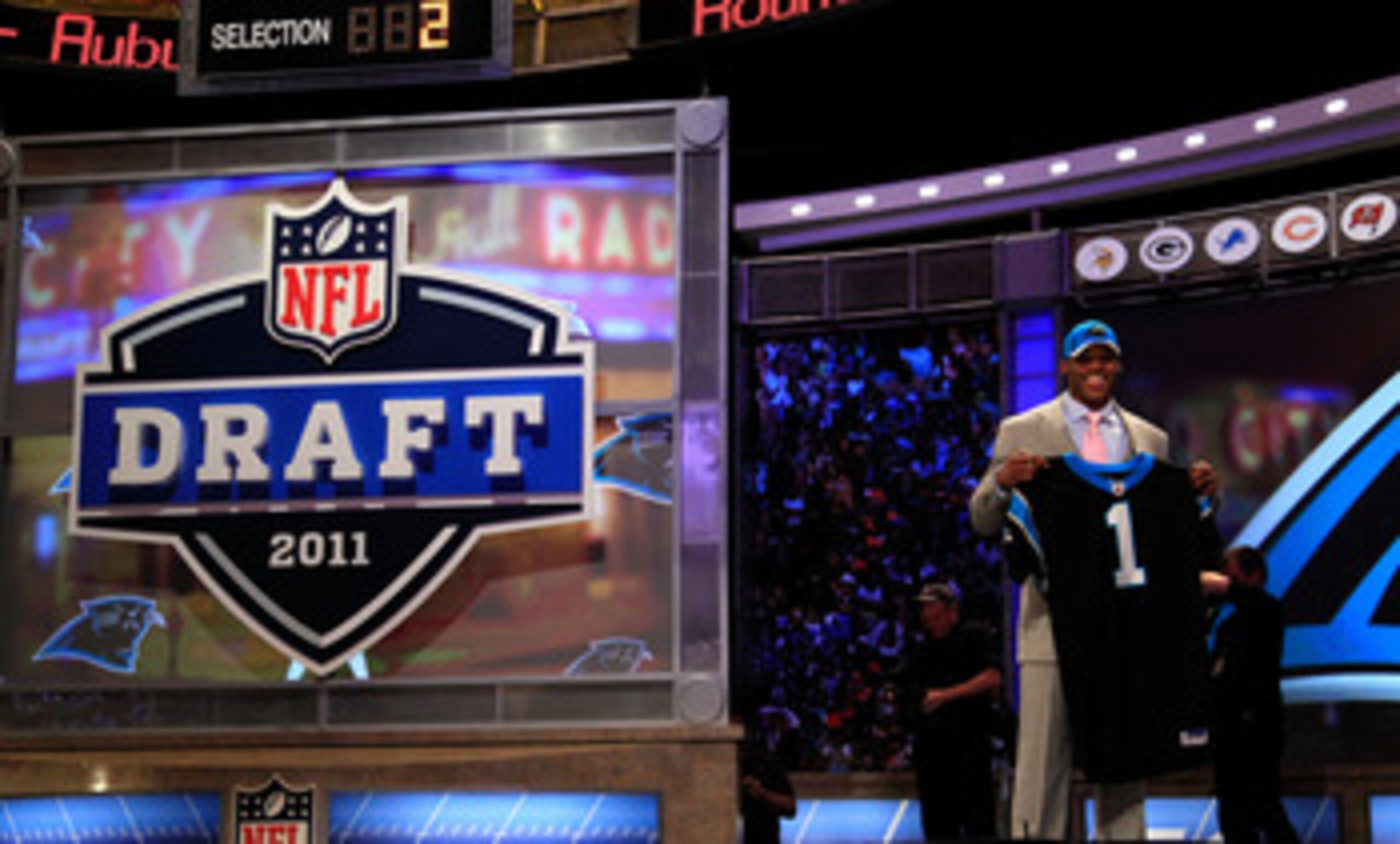 NEW YORK, NY - APRIL 28: Cam Newton, #1 overall pick by the Carolina Panthers holds up a jersey on stage after he was picked during the 2011 NFL Draft at Radio City Music Hall on April 28, 2011 in New York City. (Photo by Chris Trotman/Getty Images) NEW YORK, NY - APRIL 28: Cam Newton, #1 overall pick by the Carolina Panthers holds up a jersey on stage after he was picked during the 2011 NFL Draft at Radio City Music Hall on April 28, 2011 in New York City. (Photo by Chris Trotman/Getty Images)
