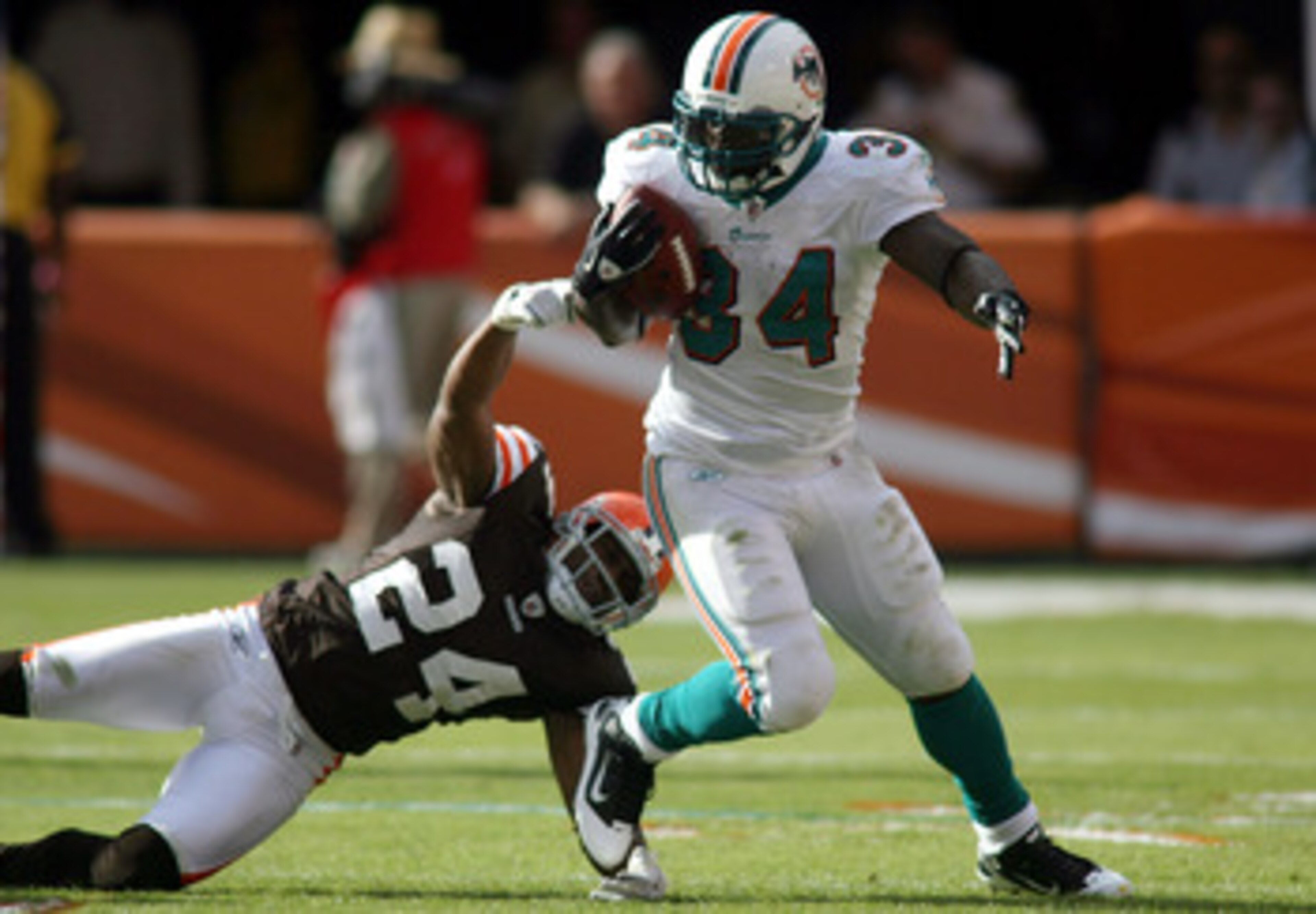 MIAMI - DECEMBER 05:  Running back Ricky Williams #34 of the Miami Dolphins is brought down by Sheldon Brown #24 of the Cleveland Browns at Sun Life Stadium on December 5, 2010 in Miami, Florida.  (Photo by Marc Serota/Getty Images)