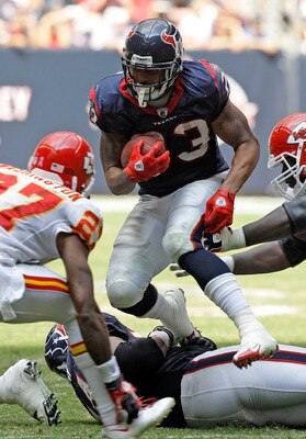 HOUSTON - OCTOBER 17:  Running back Adrian Foster #23 of the Houston Texans looks for room to run as cornerback Donald Washington #27 and  Glenn Dorsey #72 of the Kasnsas City Chiefs at Reliant Stadium on October 17, 2010 in Houston, Texas.  (Photo by Bob