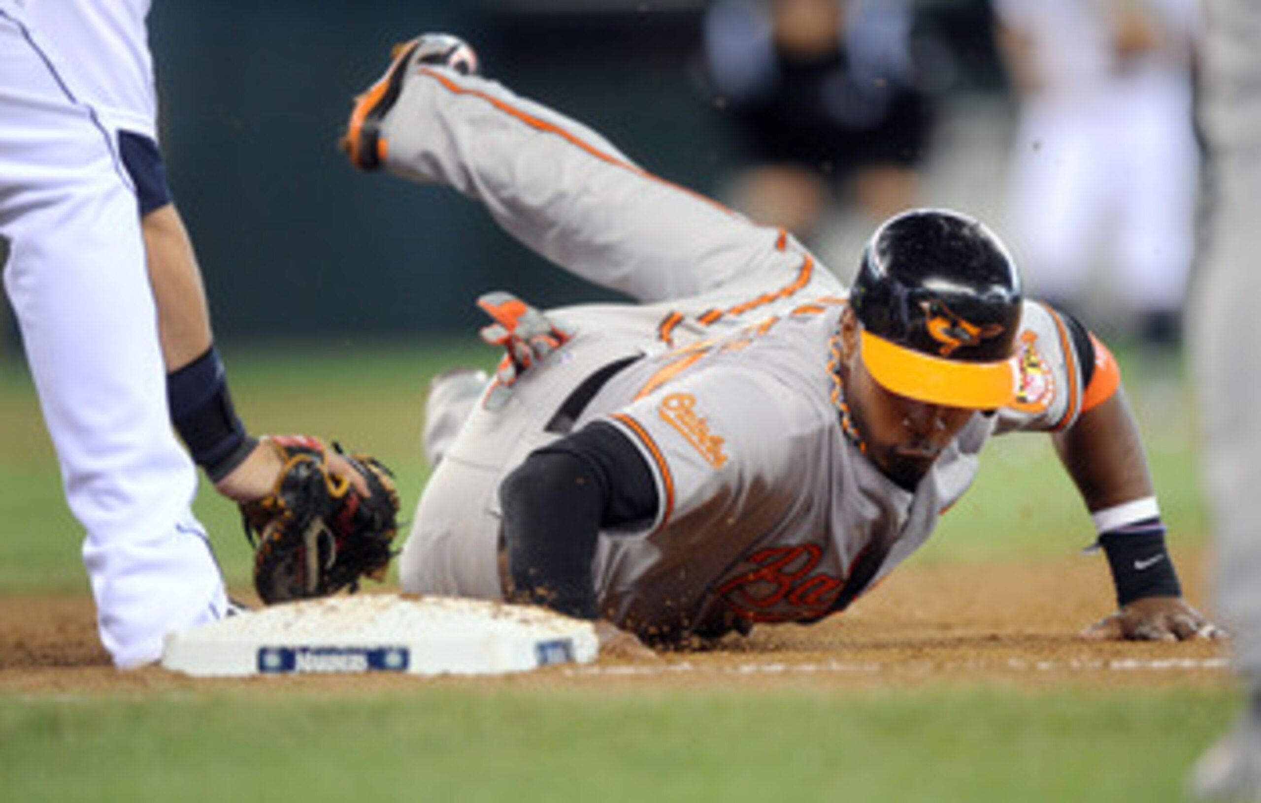 SEATTLE, WA - JUNE 1: Adam Jones #10 of the Baltimore Orioles slides back to first base during a game with the Seattle Mariners at Safeco Field on June 1, 2011 in Seattle, Washington. The Baltimore Orioles defeated the Seattle Mariners, 2-1 behind Jones' SEATTLE, WA - JUNE 1: Adam Jones #10 of the Baltimore Orioles slides back to first base during a game with the Seattle Mariners at Safeco Field on June 1, 2011 in Seattle, Washington. The Baltimore Orioles defeated the Seattle Mariners, 2-1 behind Jones'