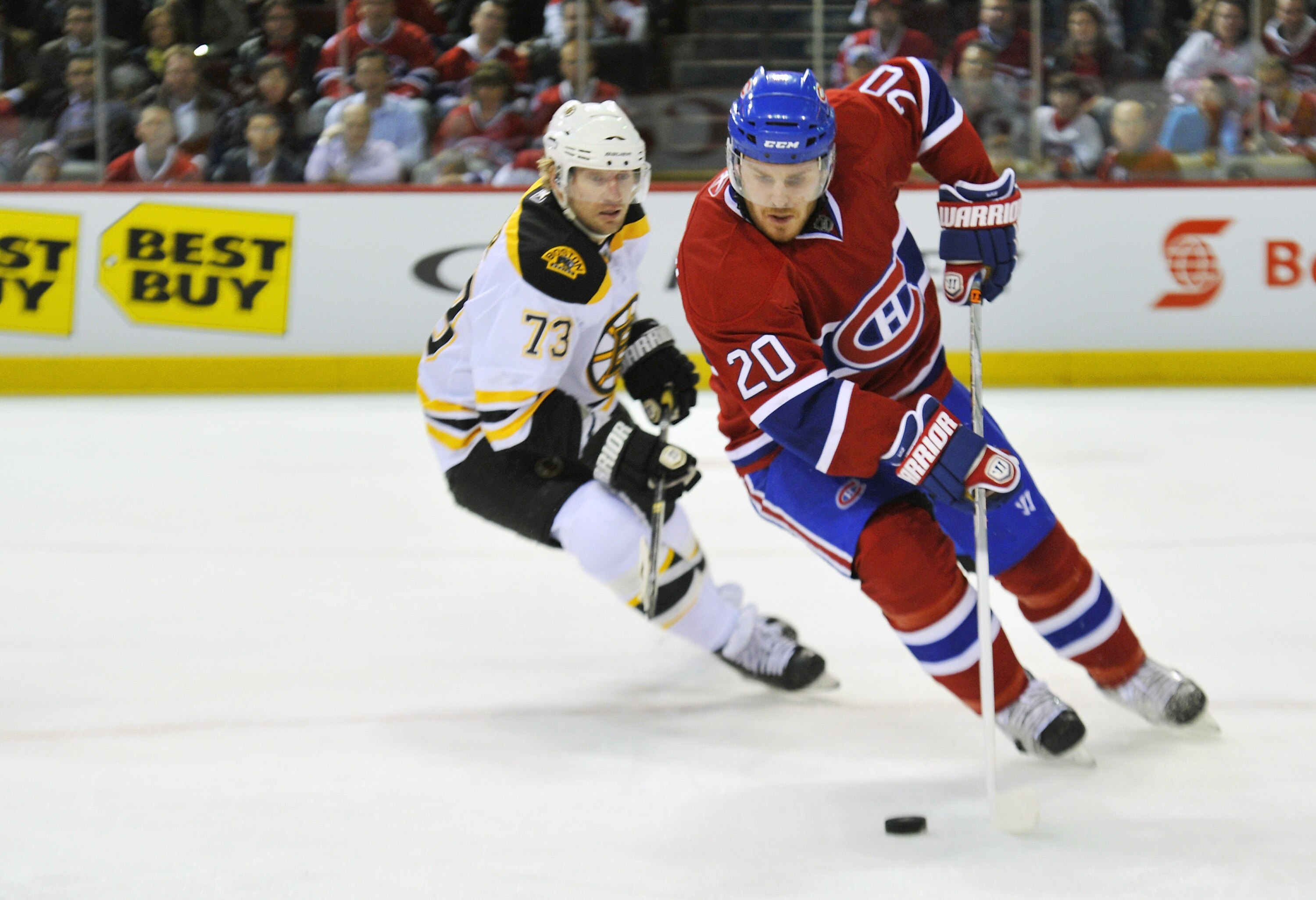 MONTREAL, QC - APRIL 18:  James Wisniewski #20 of the Montreal Canadiens turns up ice with the puck while being pursued by Michael Ryder #73 of the Boston Bruins in Game Three of the Eastern Conference Quarterfinals during the 2011 NHL Stanley Cup Playoff