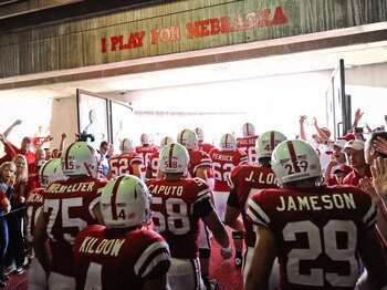 LINCOLN, NE - OCTOBER 16: The Nebraska Cornuskers run through a gauntlet of fans as they take the field against the Texas Longhorns at Memorial Stadium on October 16, 2010 in Lincoln, Nebraska. Texas Defeated Nebraska 20-13. (Photo by Eric Francis/Getty I