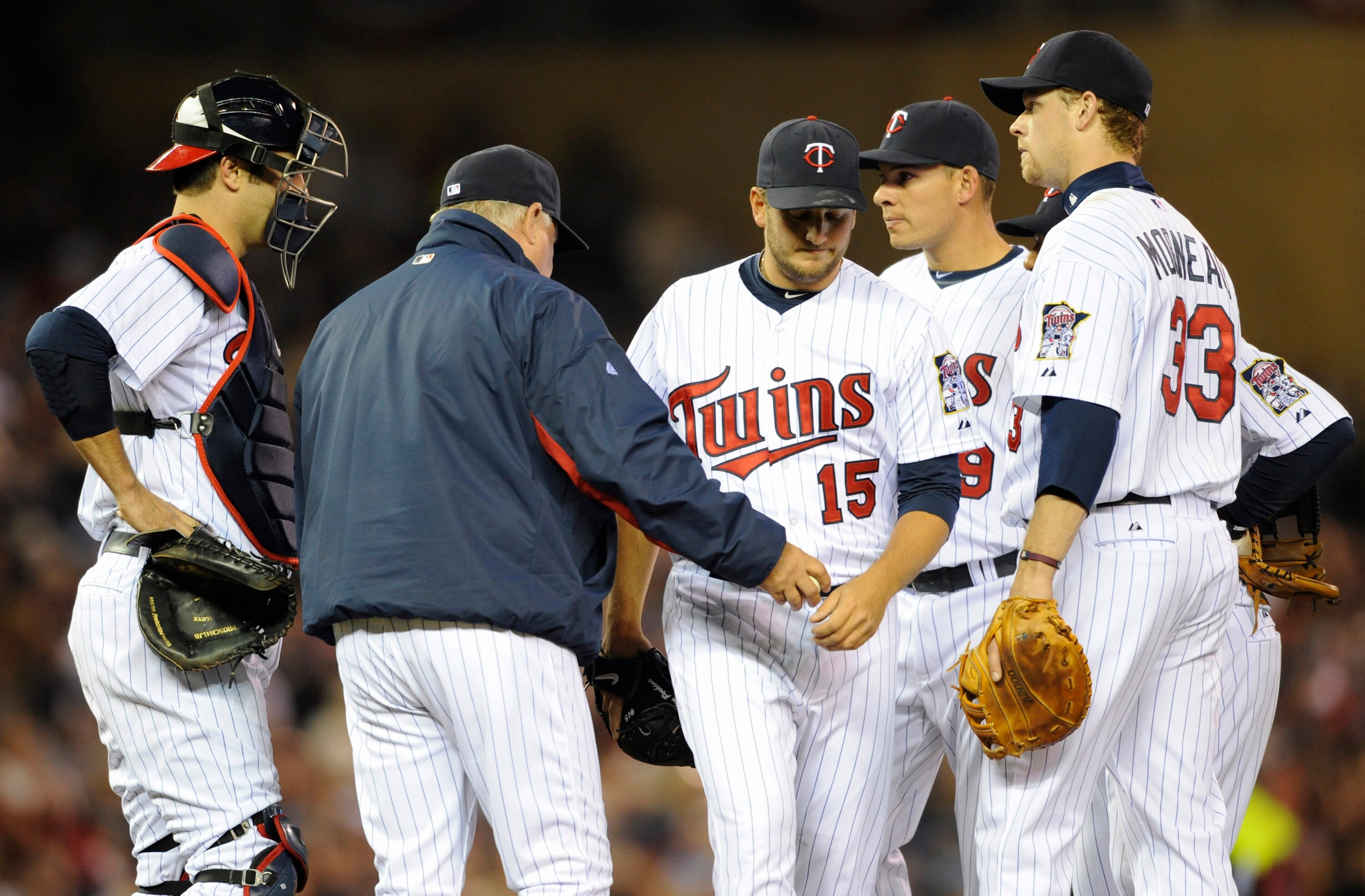 MINNEAPOLIS, MN - APRIL 9: Manager Ron Gardenhire #35 of the Minnesota Twins takes the ball from relief pitcher Glen Perkins #15 as Joe Mauer #7 (L), Danny Valencia #19 and Justin Morneau #33 look on during the seventh inning of their game against the Oak