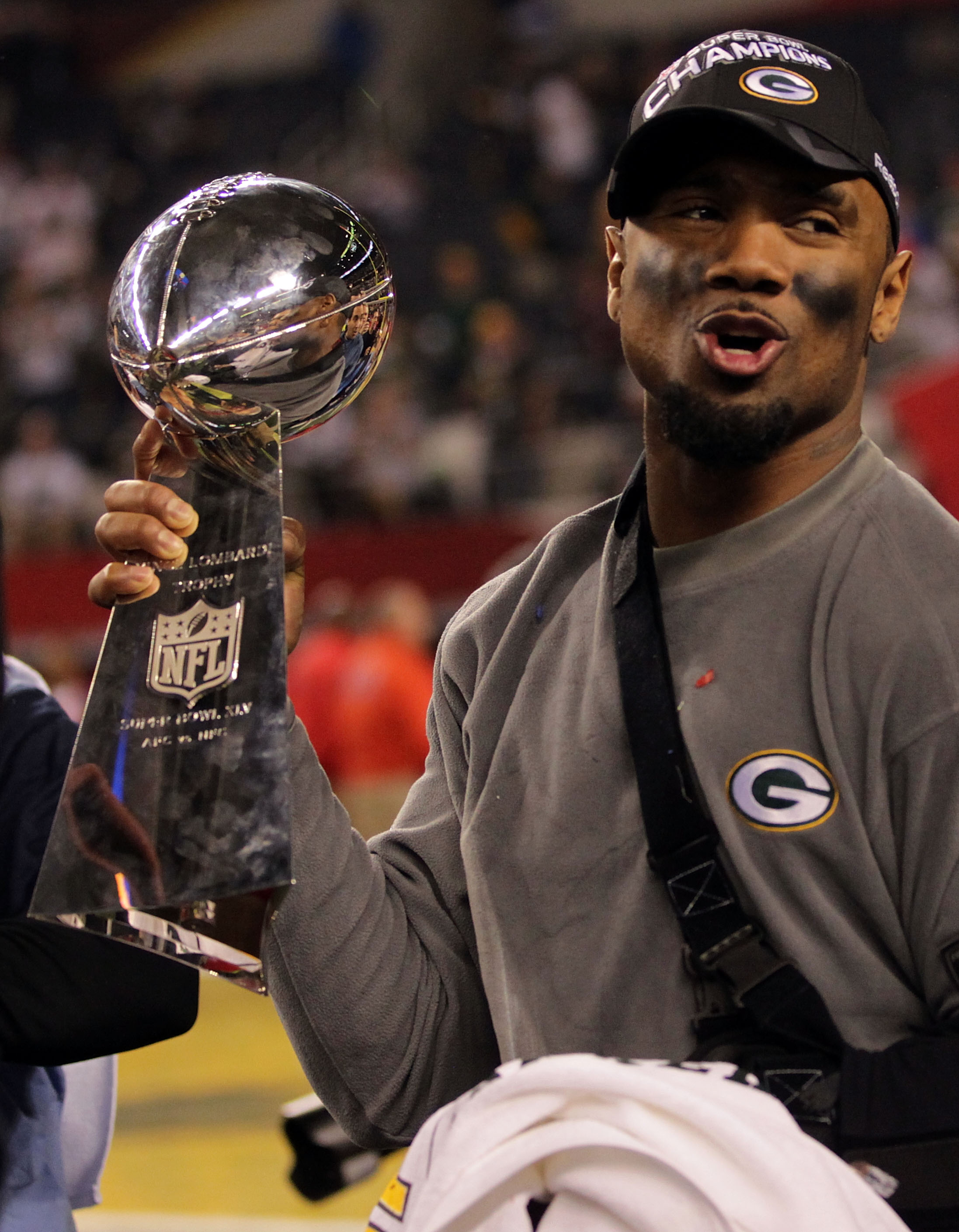 ARLINGTON, TX - FEBRUARY 06:  Charles Woodson #21 of the Green Bay Packers, who was injured during the game, celebrates with the Vince Lombardi Trophy after they defeated the Pittsburgh Steelers 31 to 25 in Super Bowl XLV at Cowboys Stadium on February 6,