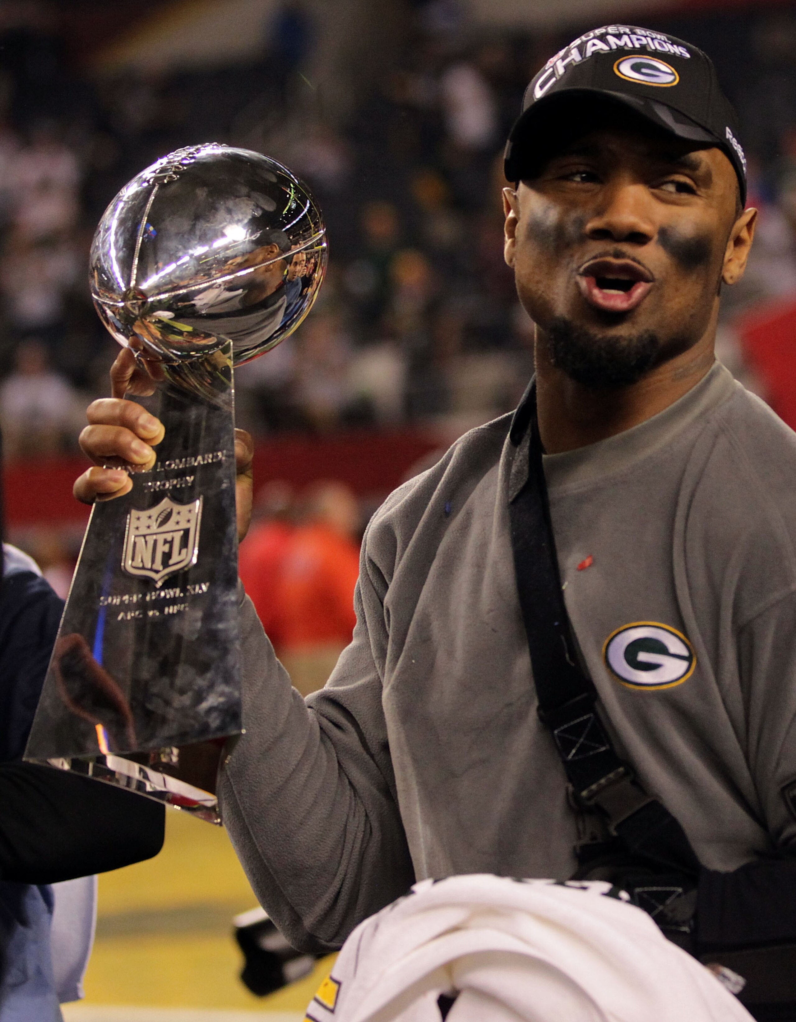 ARLINGTON, TX - FEBRUARY 06:  Charles Woodson #21 of the Green Bay Packers, who was injured during the game, celebrates with the Vince Lombardi Trophy after they defeated the Pittsburgh Steelers 31 to 25 in Super Bowl XLV at Cowboys Stadium on February 6,