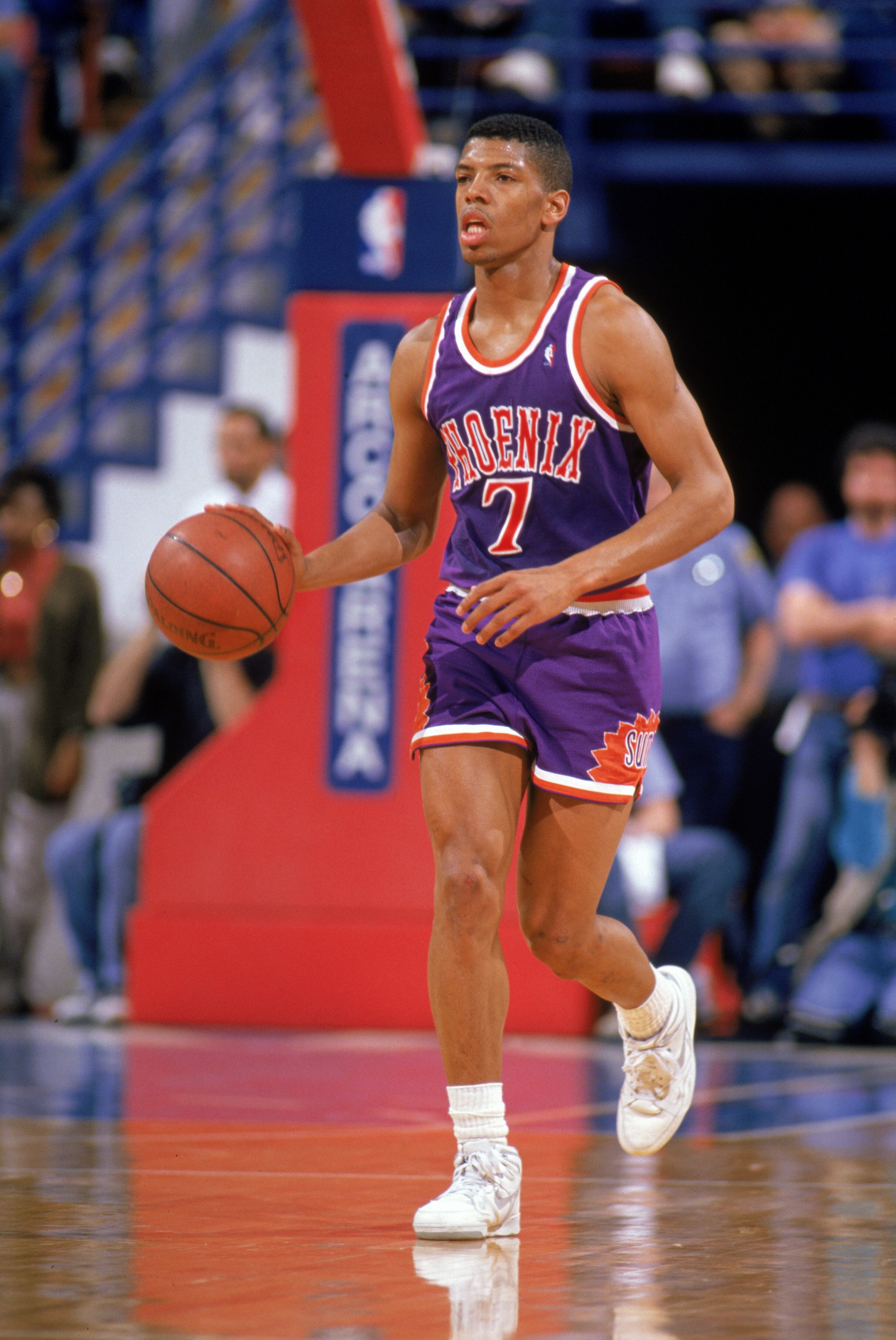 PHOENIX - 1989:  Kevin Johnson #7 of the Phoenix Suns dribbles up court during a 1989 season NBA game at Veteran's Memorial Coliseum in Phoenix, Arizona.  (Photo by Otto Greule Jr/Getty Images)