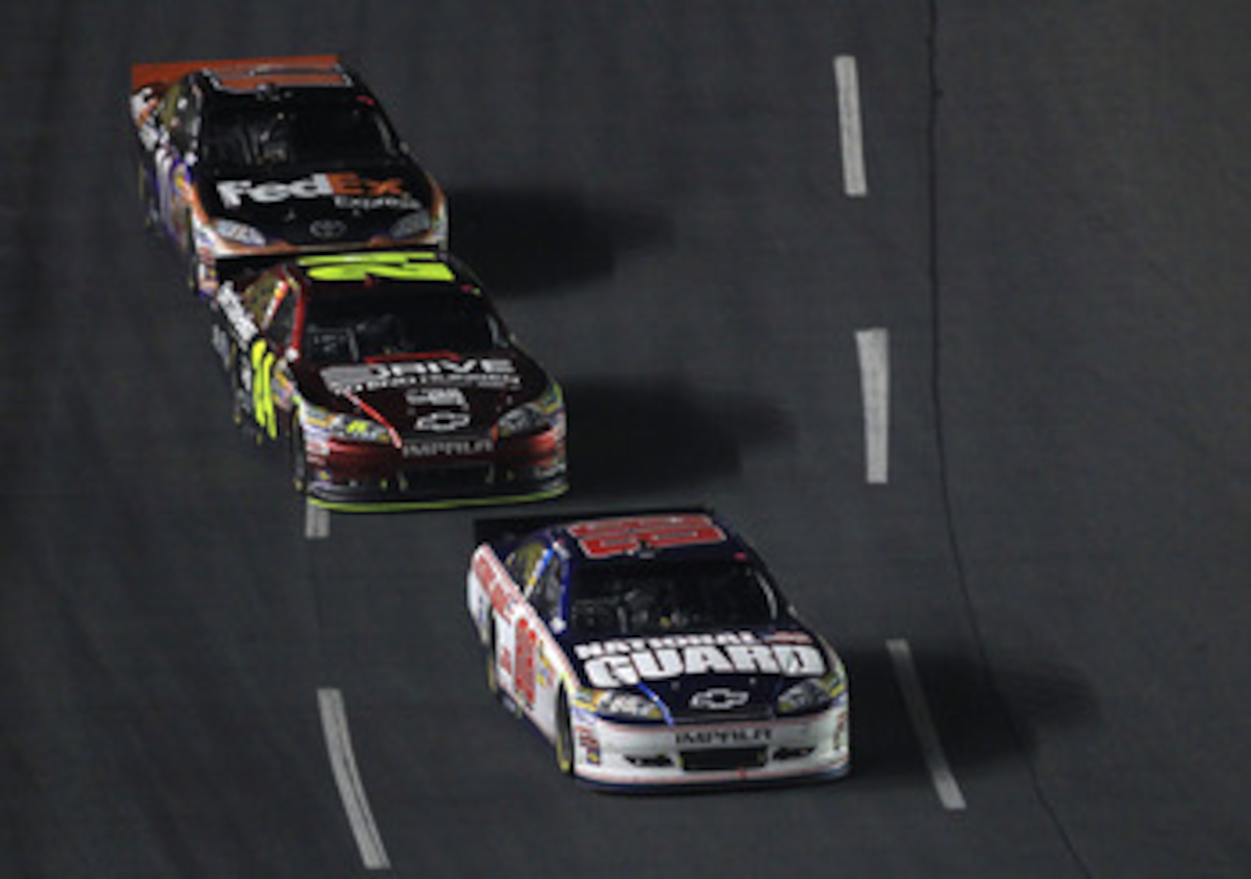 CONCORD, NC - MAY 29:  Dale Earnhardt Jr., driver of the #88 National Guard/Amp Energy Chevrolet, leads Jeff Gordon, driver of the #24 Drive to End Hunger/AARP Chevrolet, and Denny Hamlin, driver of the #11 FedEx Express Toyota, during the NASCAR Sprint C