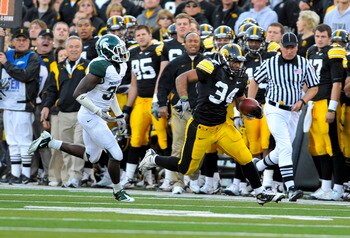 IOWA CITY, IA - OCTOBER 30- Running back Marcus Coker #34 of the University of Iowa Hawkeyes runs past Darqueze Dennard #31 of the Michigan State Spartans during the second half of play at Kinnick Stadium on October 30, 2010 in Iowa City, Iowa. Iowa won 3