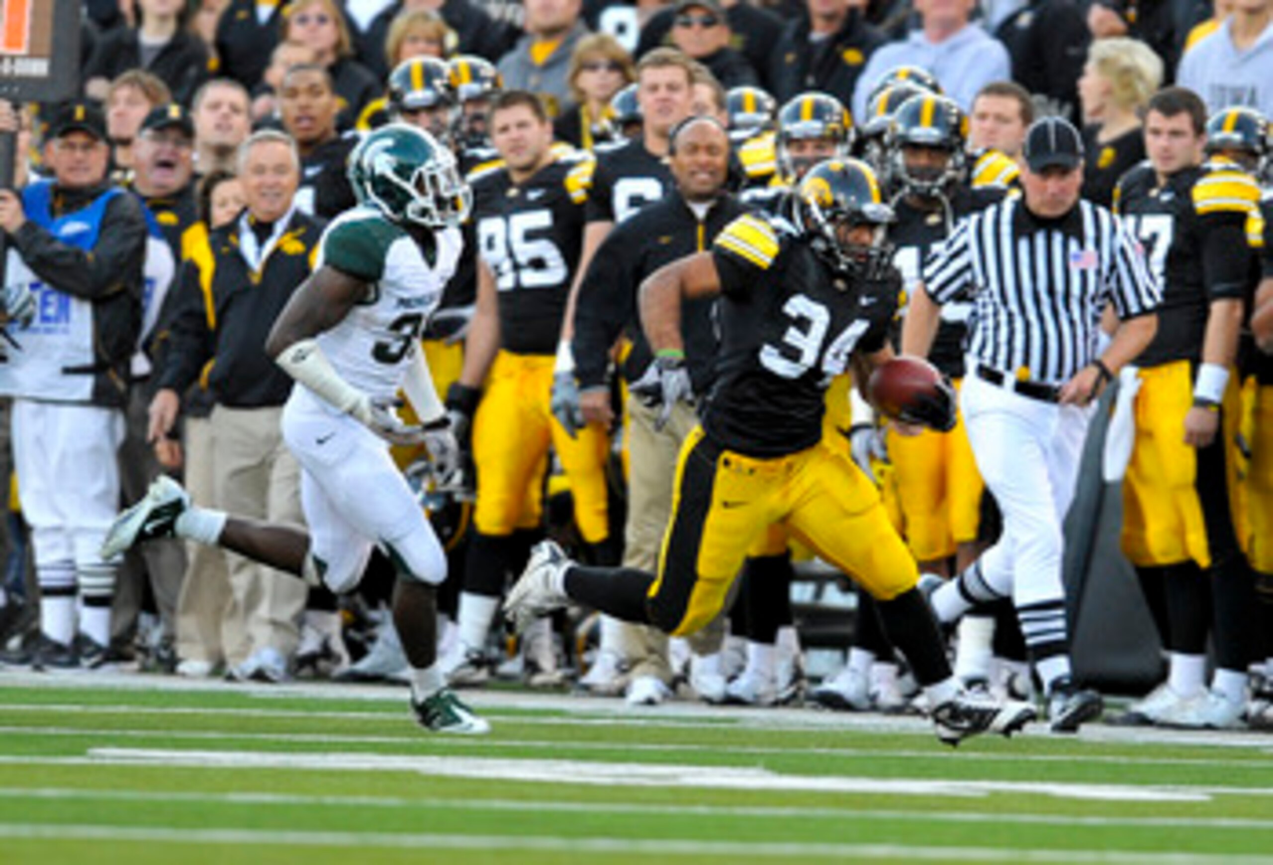 IOWA CITY, IA - OCTOBER 30- Running back Marcus Coker #34 of the University of Iowa Hawkeyes runs past Darqueze Dennard #31 of the Michigan State Spartans during the second half of play at Kinnick Stadium on October 30, 2010 in Iowa City, Iowa. Iowa won 3