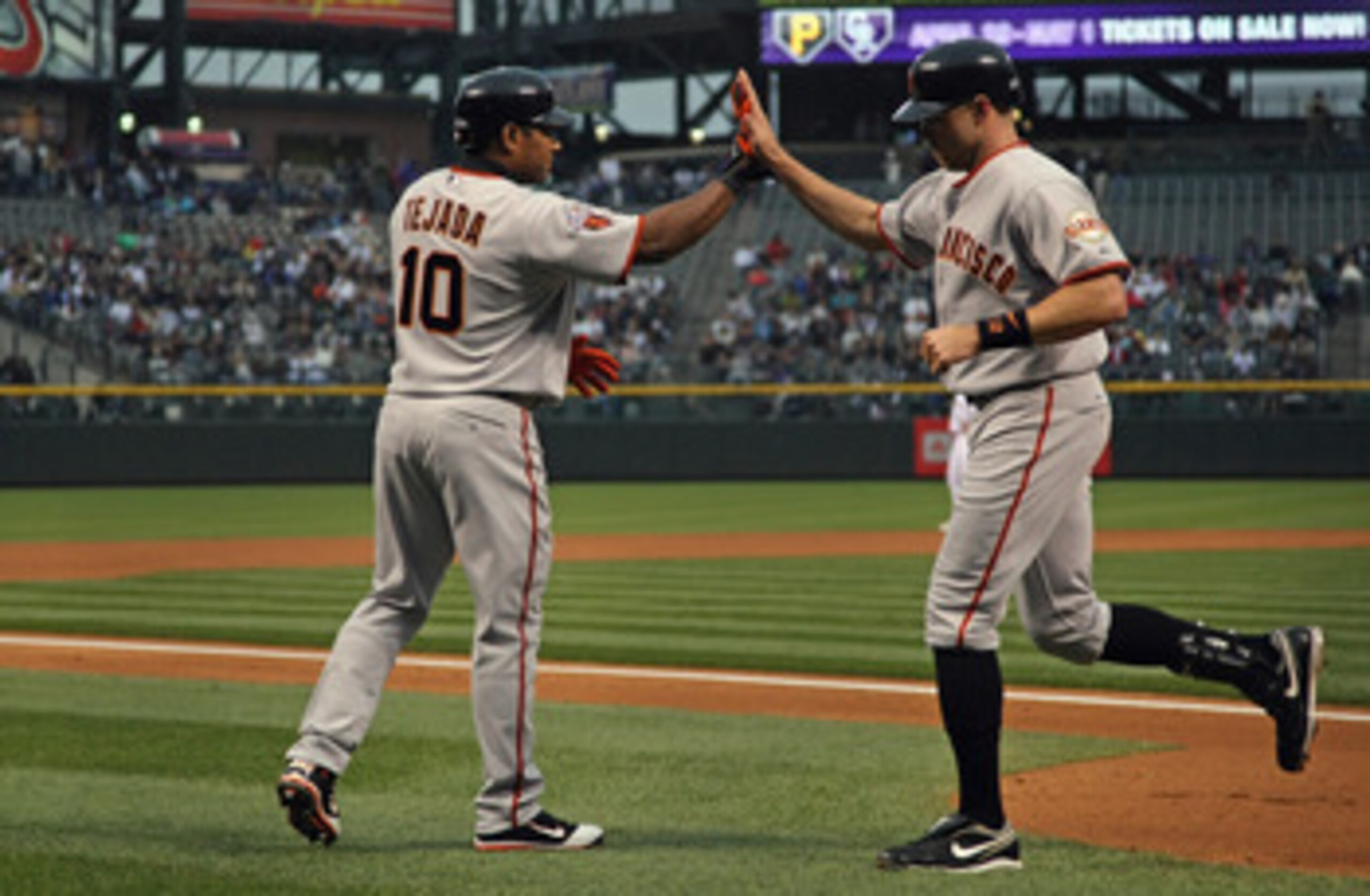 DENVER, CO - APRIL 18:  Nate Schierholtz #12 of the San Francisco Giants is welcomed home by Miguel Tejada #10 of the San Francisco Giants after his solo homerun in the first inning off of starting pitcher Esmil Rogers #48 of the Colorado Rockies at Coors