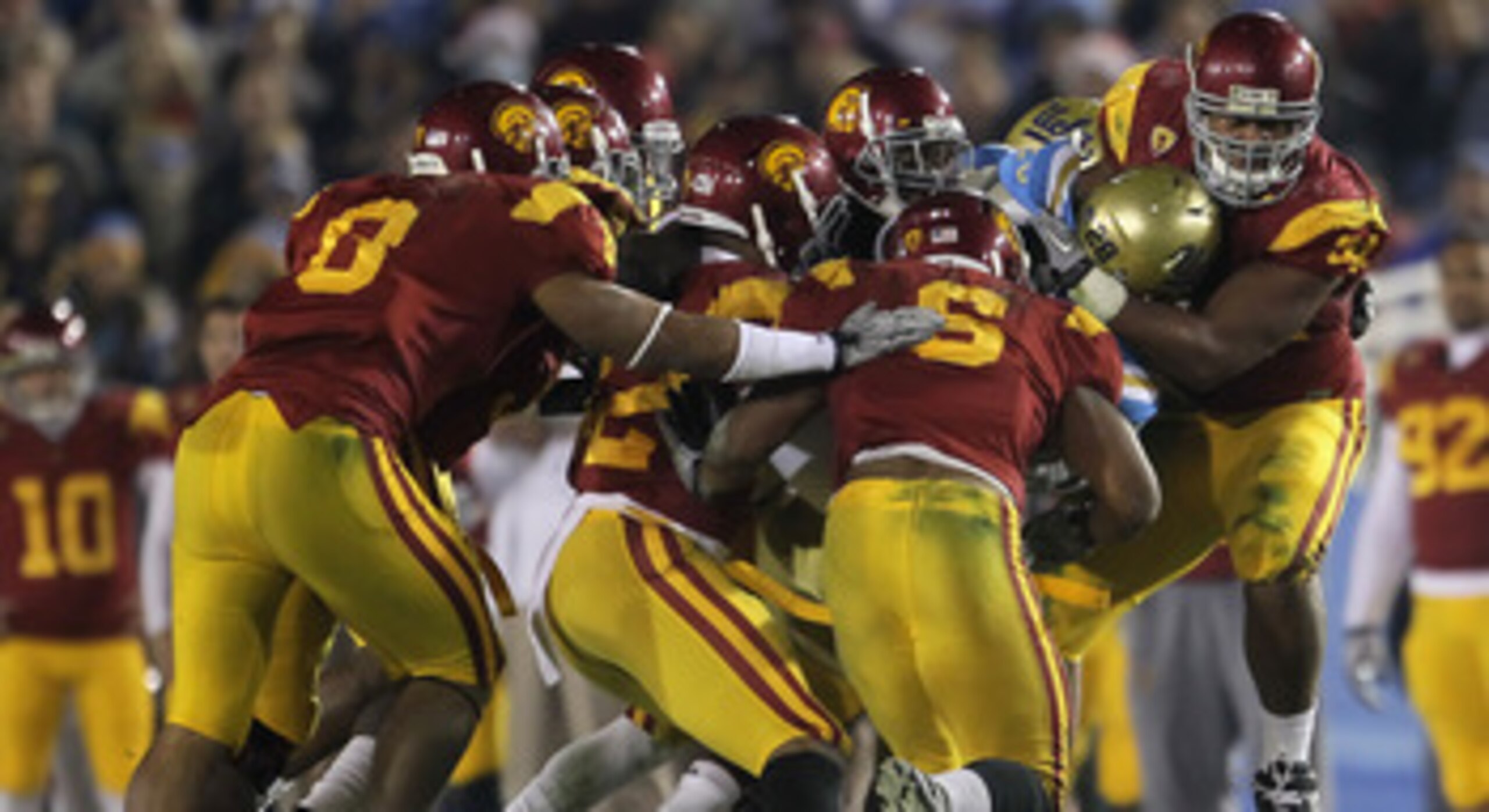 PASADENA, CA - DECEMBER 04:  Chris Galippo (R) #54 of the USC Trojans tackles Malcolm Jones #28 of the UCLA Bruins during the second half at the Rose Bowl on December 4, 2010 in Pasadena, California. USC defeated UCLA 28-14.  (Photo by Jeff Gross/Getty Im