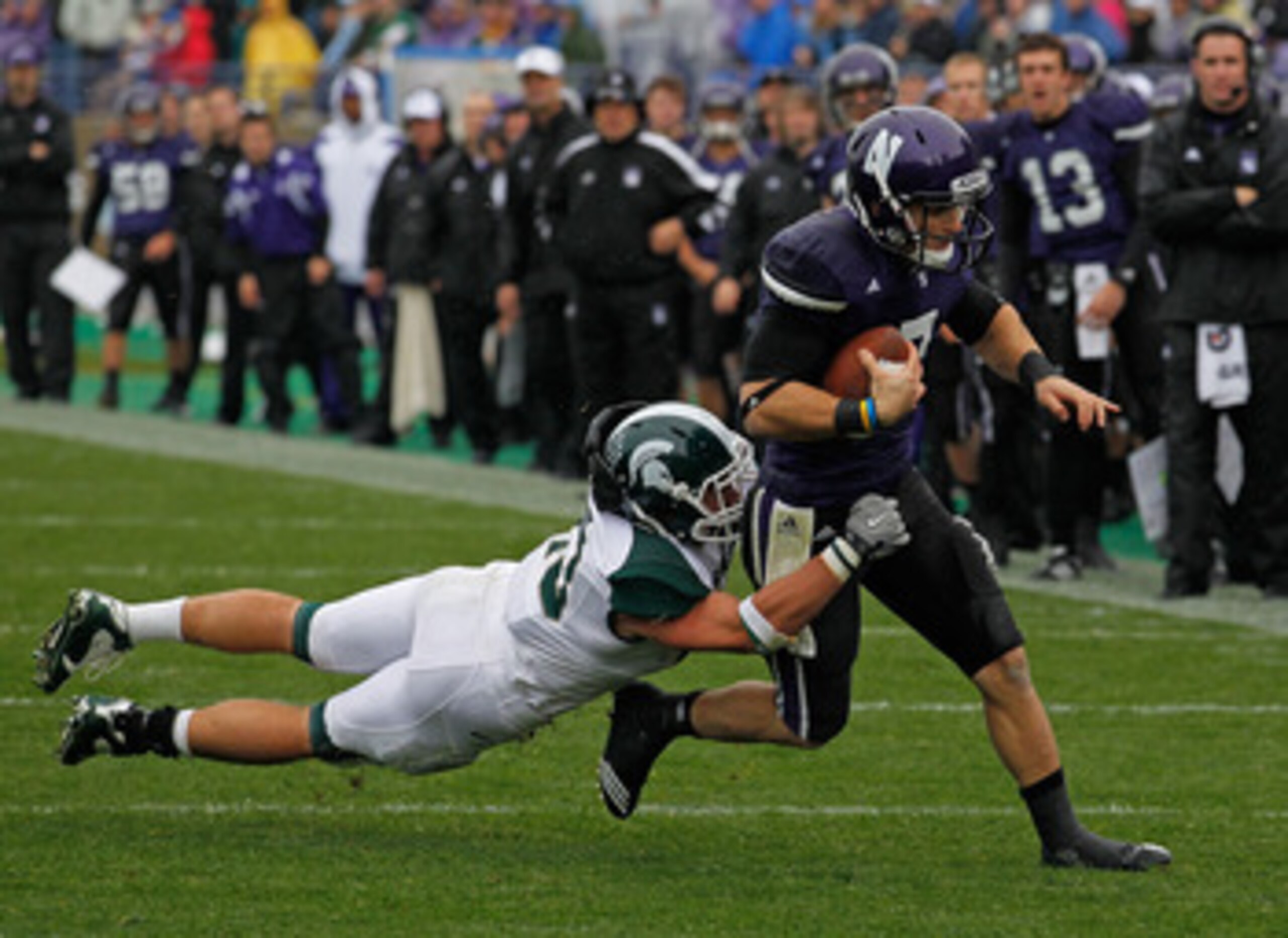 EVANSTON, IL - OCTOBER 23: Dan Persa #7 of the Northwestern Wildcats escapes a tackle attempt by Eric Gordon #43 of the Michigan State Spartans at Ryan Field on October 23, 2010 in Evanston, Illinois. Michigan State defeated Northwestern 35-27.  (Photo by
