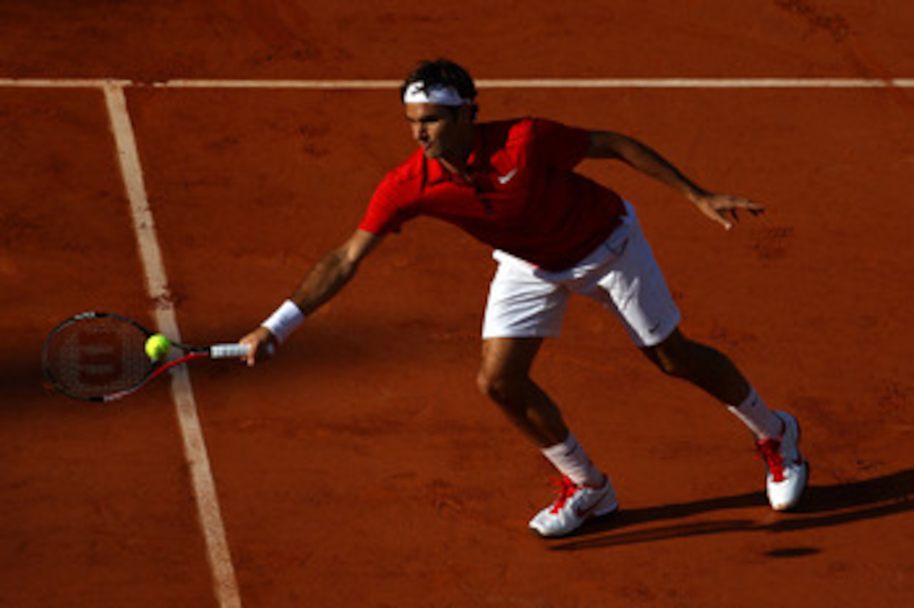 PARIS, FRANCE - MAY 31:  Roger Federer of Switzerland sits a forehand during the men's singles quarterfinal match between Gael Monfils of France and Roger Federer of Switzerland on day ten of the French Open at Roland Garros on May 31, 2011 in Paris, Fran