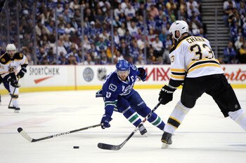 VANCOUVER, BC - JUNE 01:  Henrik Sedin #33 of the Vancouver Canucks skates with the puck against Zdeno Chara #33 of the Boston Bruins during game one of the 2011 NHL Stanley Cup Finals at Rogers Arena on June 1, 2011 in Vancouver, Canada.  (Photo by Harry