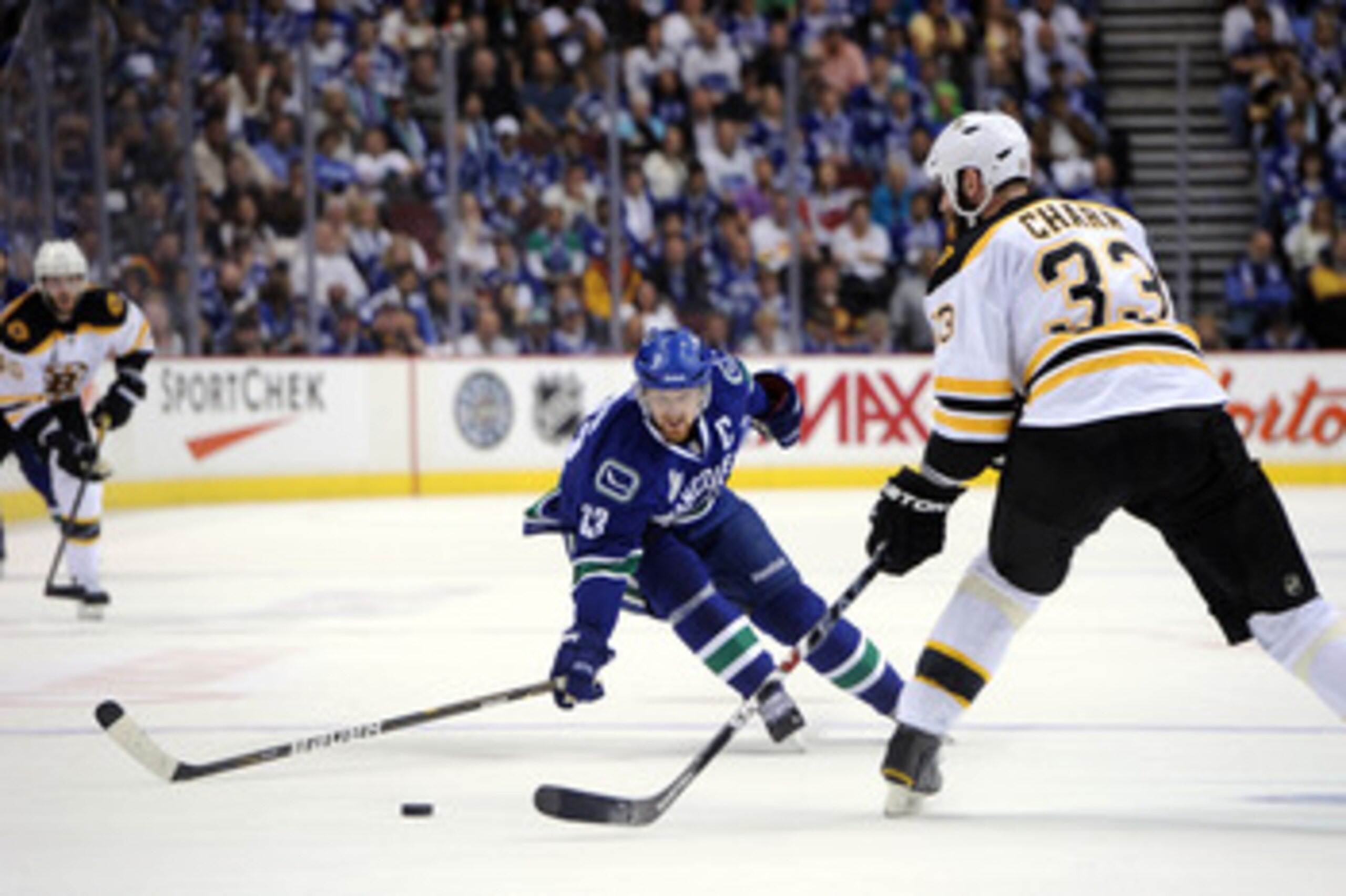 VANCOUVER, BC - JUNE 01:  Henrik Sedin #33 of the Vancouver Canucks skates with the puck against Zdeno Chara #33 of the Boston Bruins during game one of the 2011 NHL Stanley Cup Finals at Rogers Arena on June 1, 2011 in Vancouver, Canada.  (Photo by Harry