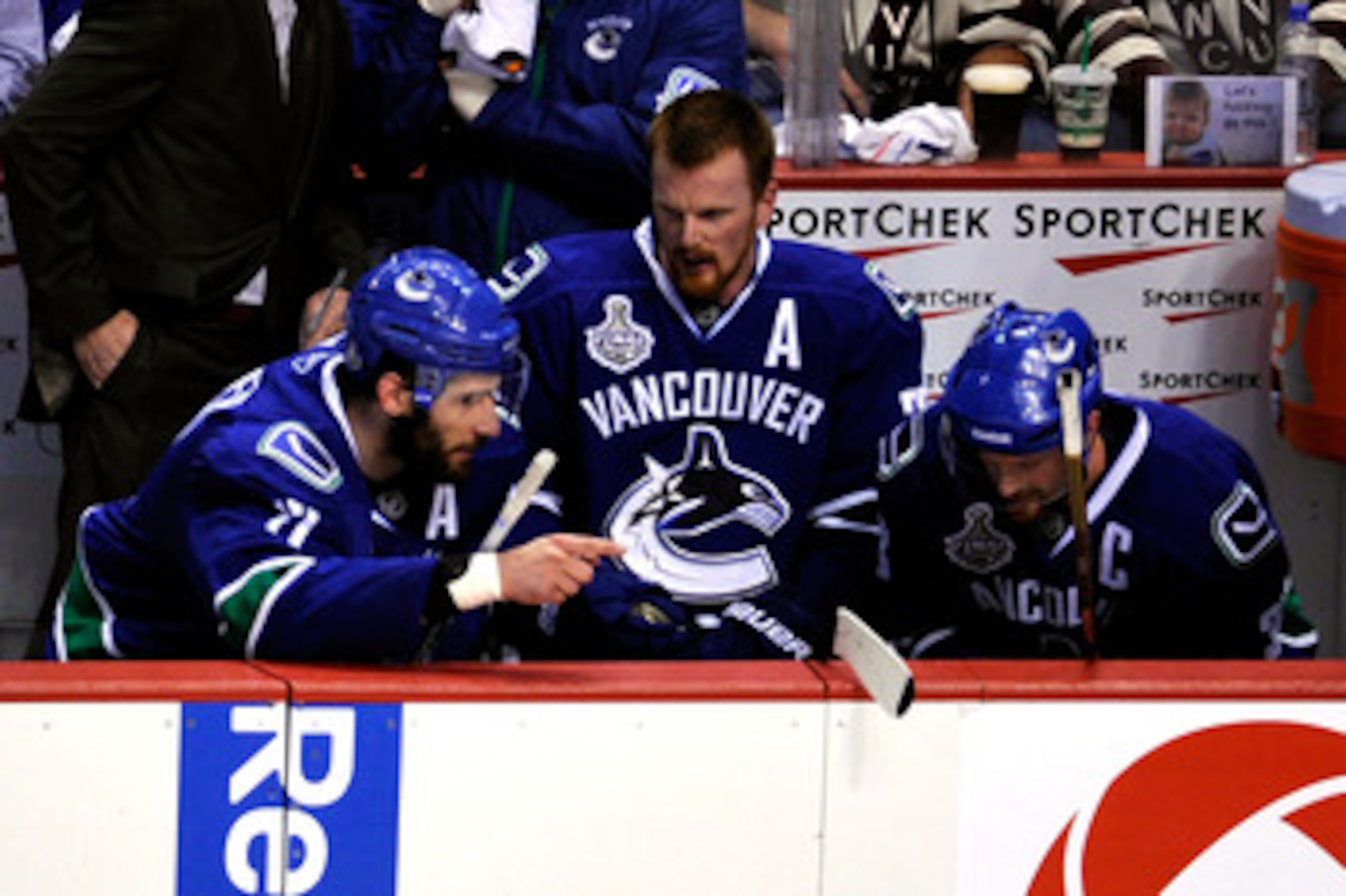 VANCOUVER, BC - JUNE 01:  (L-R) Ryan Kesler #17, Daniel Sedin #22 and Henrik Sedin #33 of the Vancouver Canucks talk on the bench during game one against the Boston Bruins in the 2011 NHL Stanley Cup Finals at Rogers Arena on June 1, 2011 in Vancouver, Ca