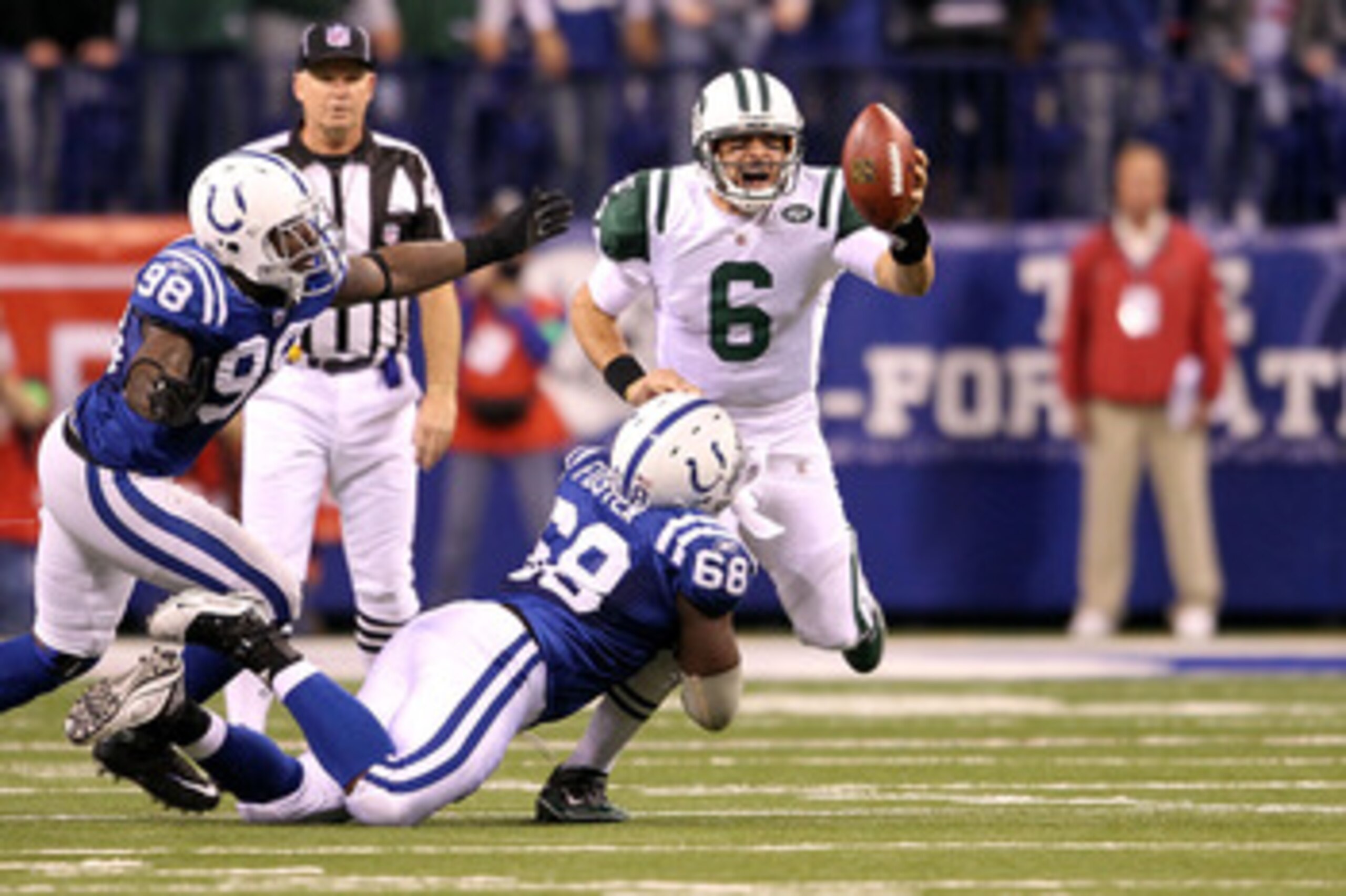 INDIANAPOLIS, IN - JANUARY 08:  Quarterback Mark Sanchez #6 of the New York Jets attempts to escape the pressure by Eric Foster #68 and Robert Mathis #98 of the Indianapolis Colts during their 2011 AFC wild card playoff game at Lucas Oil Stadium on Januar