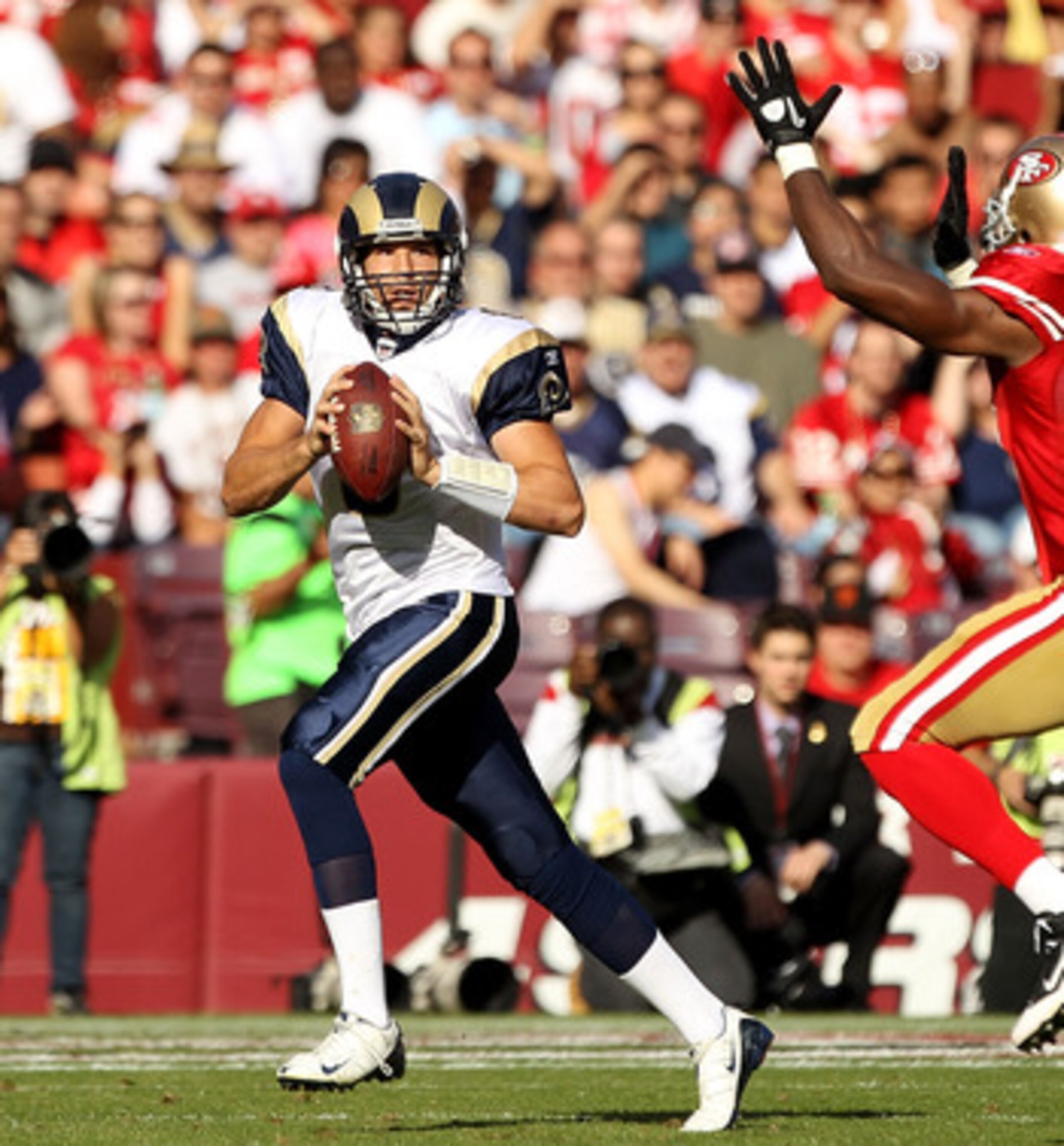 SAN FRANCISCO - NOVEMBER 14:  Sam Bradford #8  of the St. Louis Rams is chased by Manny Lawson #99 of the San Francisco 49ers at Candlestick Park on November 14, 2010 in San Francisco, California.  (Photo by Ezra Shaw/Getty Images)