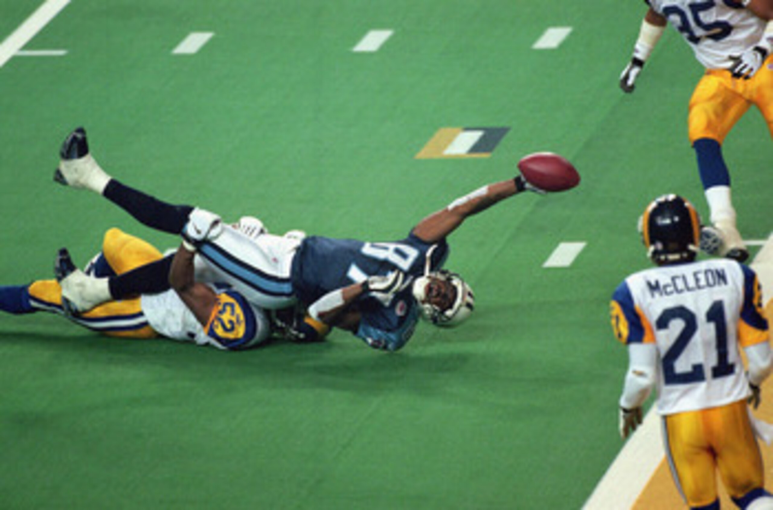 ATLANTA - JANUARY 30:  Kevin Dyson #87 of the Tennessee Titans reaches for the end zone with the ball as Mike Jones #52 of the St. Louis Rams tackles him on the last play of the game during the Super Bowl XXXIV Game at the Georgia Dome on January 30, 2000