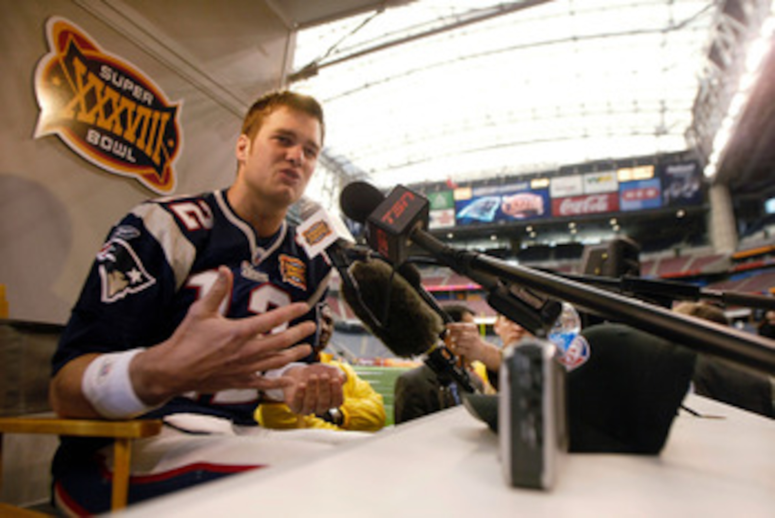 HOUSTON - JANUARY 27:  Quarterback Tom Brady #12 of the New England Patriots answers questions during media day on January 27, 2003 at Reliant Stadium in Houston, Texas. The New England Patriots and Carolina Panthers will play in Super Bowl XXXVIII on Feb