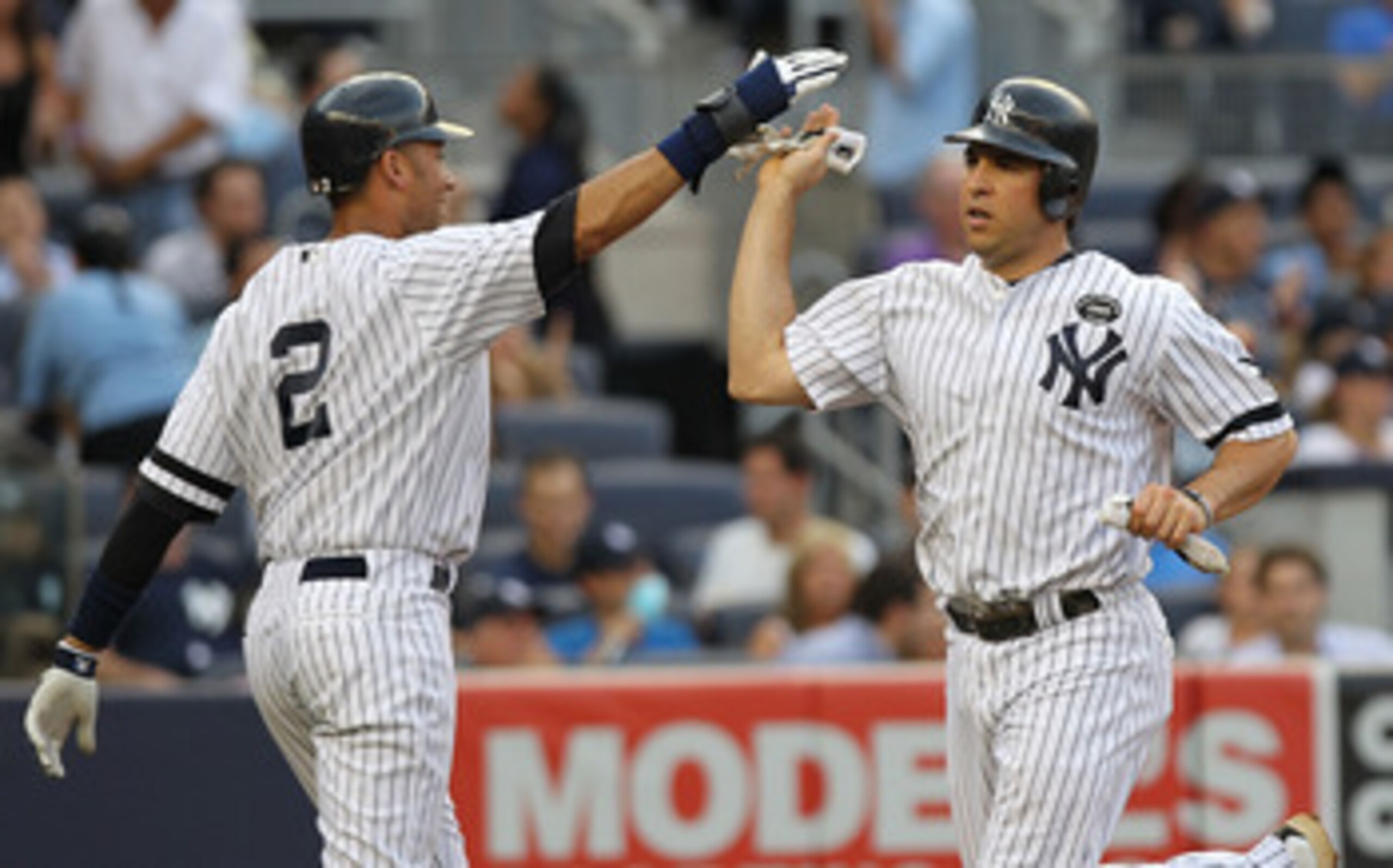 NEW YORK - JULY 22:  Derek Jeter #2 of the New York Yankees celebrates scoring with teammate Mark Teixeira #25 on an Alex Rodriguez #13 double in the first against the Kansas City Royals at Yankee Stadium on July 22, 2010 in the Bronx borough of New York