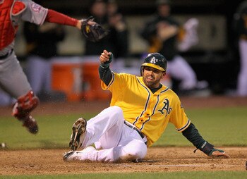 OAKLAND, CA - MAY 17:  David DeJesus #12 of the Oakland Athletics scores on a double by Mark Ellis #14 of the Oakland Athletics in the second inning of their game against the Los Angeles Angels of Anaheim at Oakland-Alameda County Coliseum on May 17, 2011