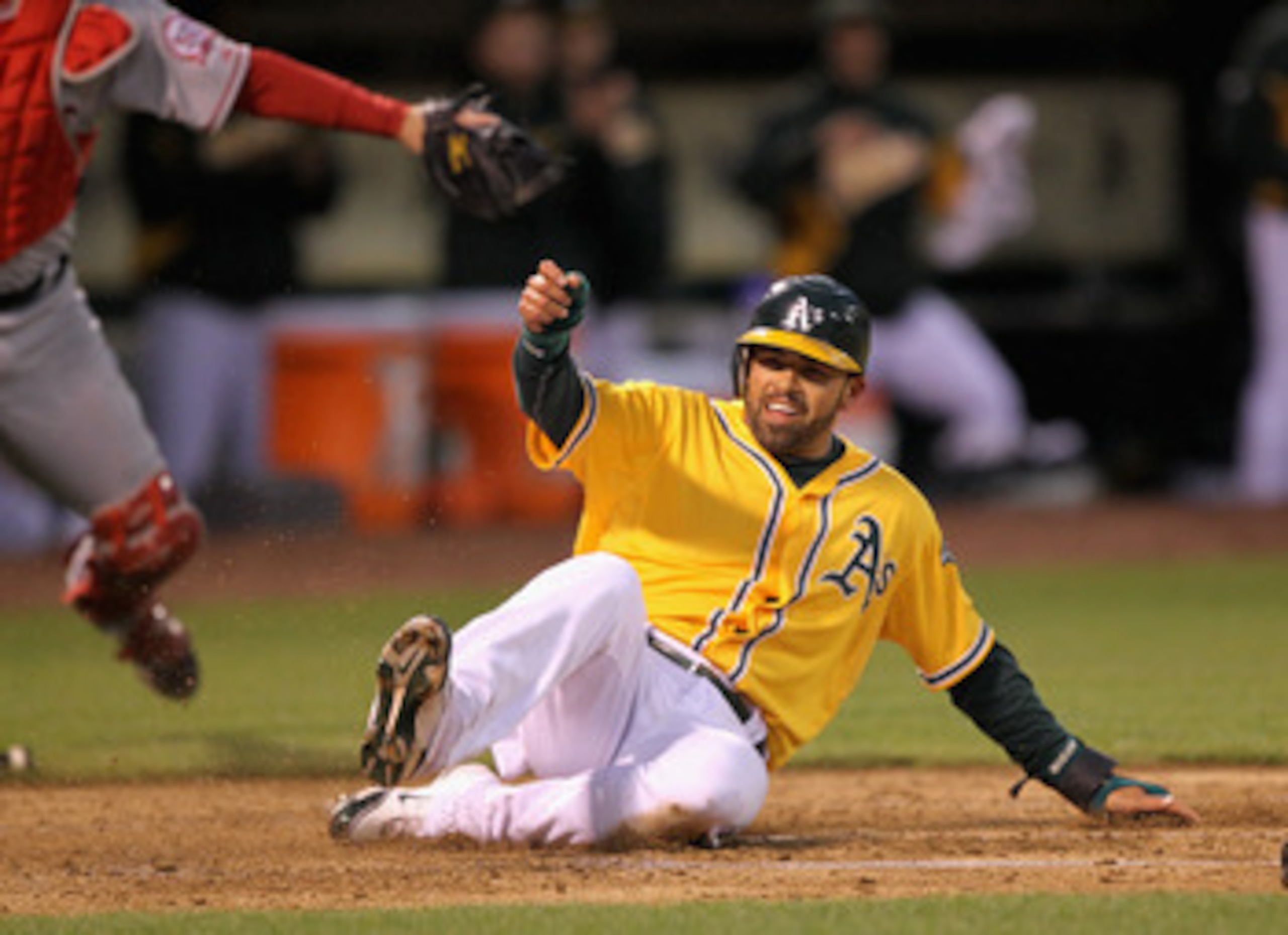 OAKLAND, CA - MAY 17:  David DeJesus #12 of the Oakland Athletics scores on a double by Mark Ellis #14 of the Oakland Athletics in the second inning of their game against the Los Angeles Angels of Anaheim at Oakland-Alameda County Coliseum on May 17, 2011