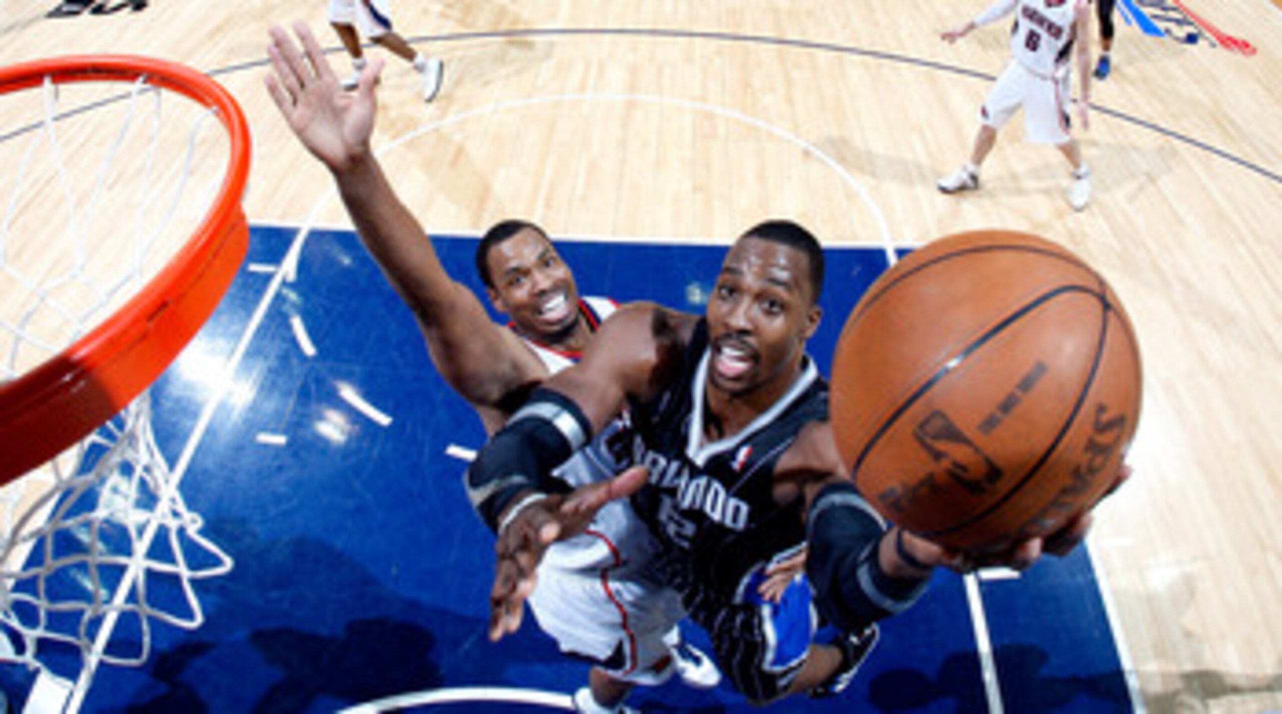 ATLANTA, GA - APRIL 24:  Dwight Howard #12 of the Orlando Magic attacks the basket against Jason Collins #34 of the Atlanta Hawks during Game Four of the Eastern Conference Quarterfinals in the 2011 NBA Playoffs at Philips Arena on April 24, 2011 in Atlan