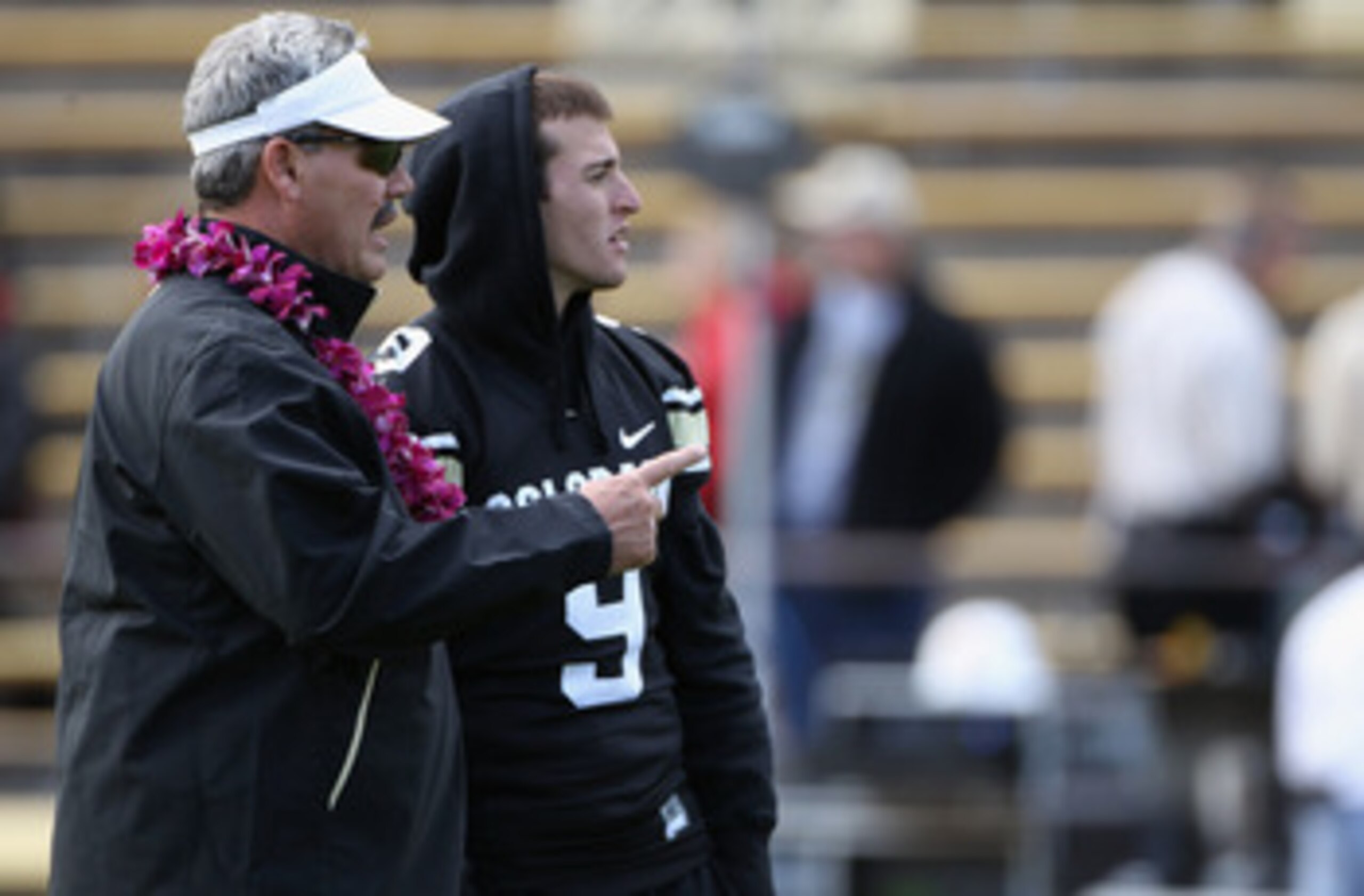 BOULDER, CO - NOVEMBER 13:  Interim head coach Brian Cabral talks with injured quarterback Tyler Hansen #9 of the Colorado Buffaloes during warm ups as they prepare to face the Iowa State Cyclones at Folsom Field on November 13, 2010 in Boulder, Colorado.