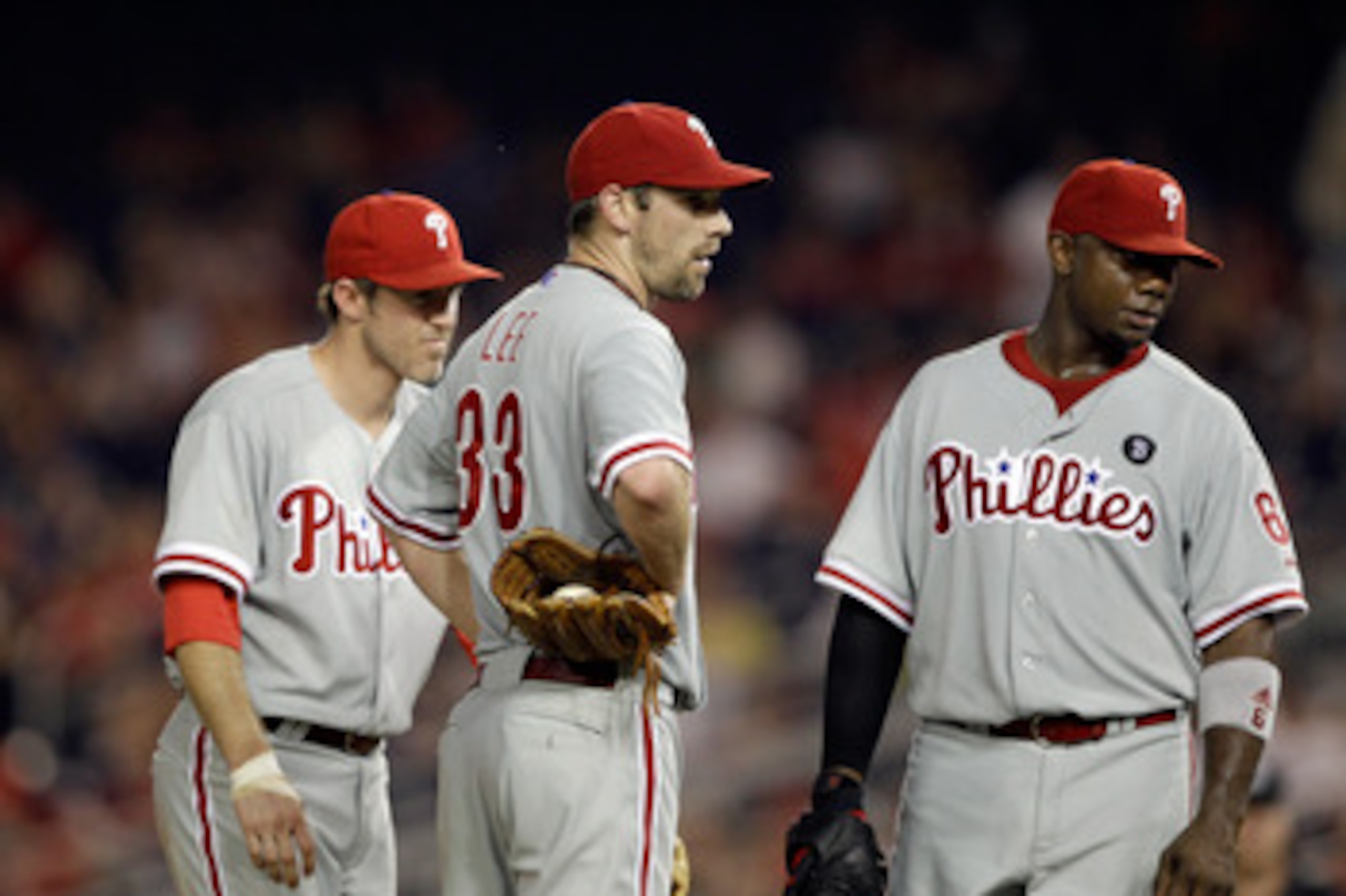 WASHINGTON, DC - MAY 31:  Second baseman Chase Utley #26 of the Philadelphia Phillies (L) talks with pitcher Cliff Lee #33 (C) and first baseman Ryan Howard #6 (R) during a pitching change against the Washington Nationals at Nationals Park on May 31, 2011