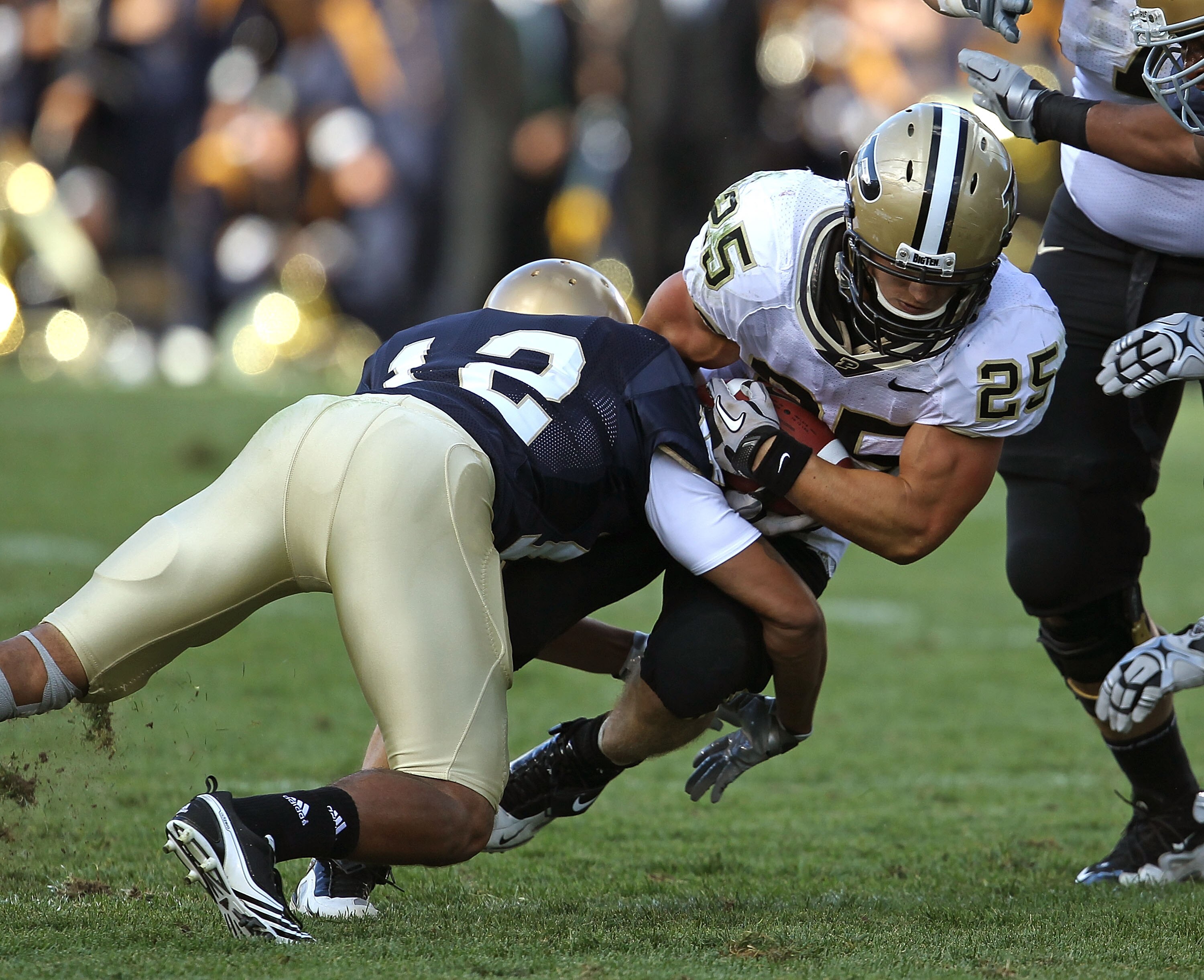 SOUTH BEND, IN - SEPTEMBER 04: Dan Dierking #25 of the Purdue Boilermakers is hit by Robert Blanton #12 of the Notre Dame Fighting Irish at Notre Dame Stadium on September 4, 2010 in South Bend, Indiana. Notre Dame defated Purdue 23-12. (Photo by Jonathan