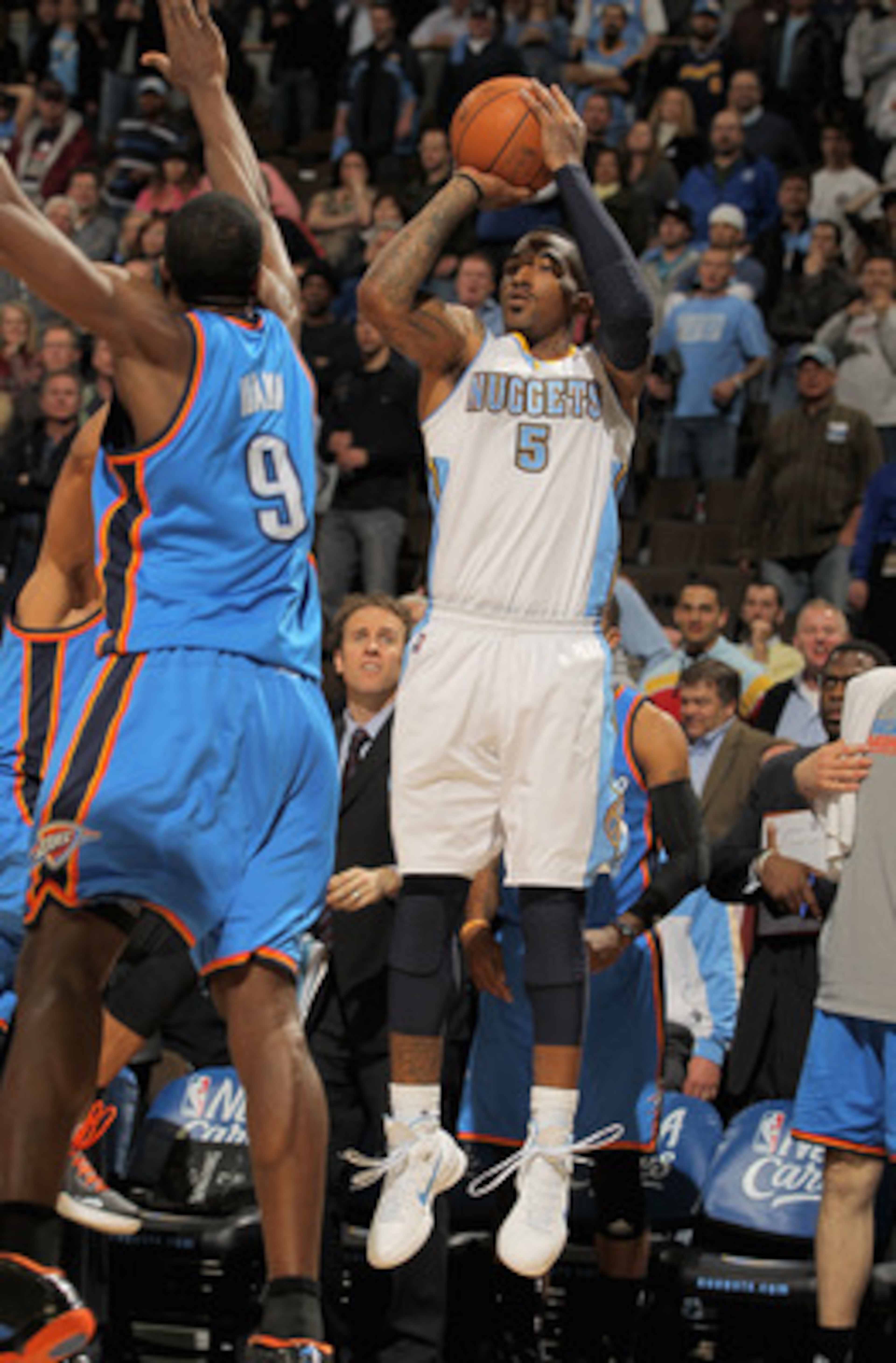 DENVER, CO - APRIL 23: J.R. Smith #5 of the Denver Nuggets makes a three point over Serge Ibaka #9 of the Oklahoma City Thunder in the final minute of the in Game Three of the Western Conference Quarterfinals in the 2011 NBA Playoffs on April 23, 2011 at DENVER, CO - APRIL 23: J.R. Smith #5 of the Denver Nuggets makes a three point over Serge Ibaka #9 of the Oklahoma City Thunder in the final minute of the in Game Three of the Western Conference Quarterfinals in the 2011 NBA Playoffs on April 23, 2011 at