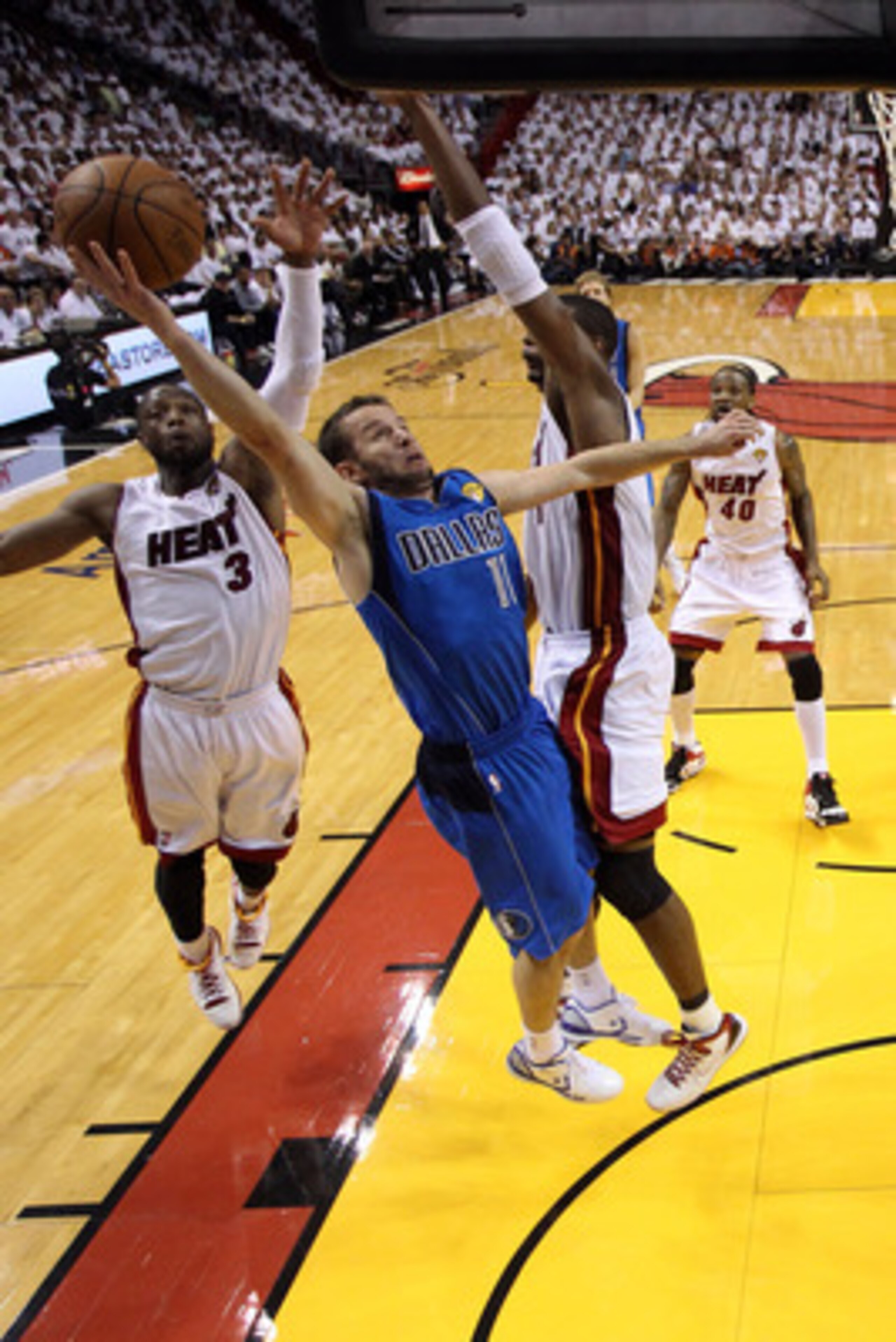 MIAMI, FL - JUNE 02:  Jose Juan Barea #11 of the Dallas Mavericks drives for a shot attempt against Chris Bosh #1 and Dwyane Wade #3 of the Miami Heat in Game Two of the 2011 NBA Finals at American Airlines Arena on June 2, 2011 in Miami, Florida. NOTE TO