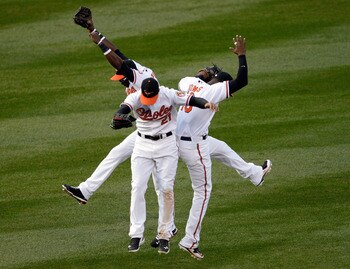 BALTIMORE, MD - APRIL 04: Felix Pie #18 of the Baltimore Orioles (L) and teammates Nick Markakis #21 (C) and Adam Jones #10 celebrate in the outfield after the Orioles defeated the Detroit Tigers 5-1 during opening day at Oriole Park at Camden Yards on Ap