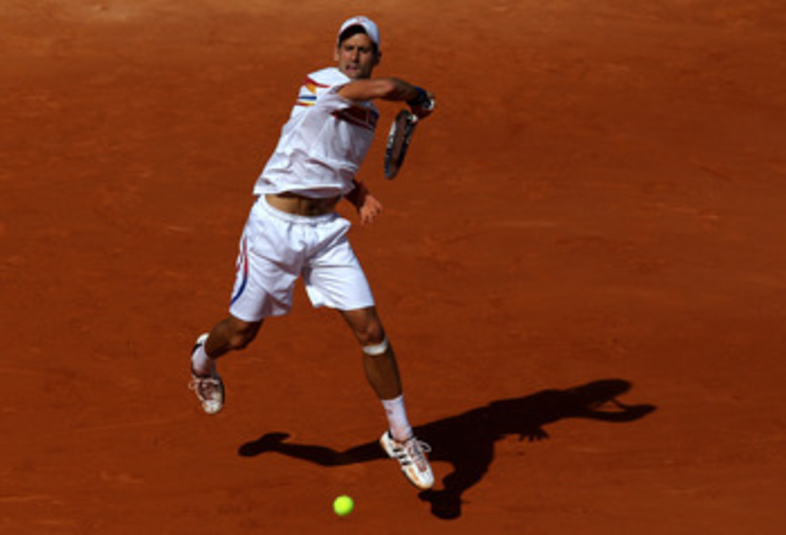 PARIS, FRANCE - MAY 29:  Novak Djokovic of Serbia hits a forehand during the men's singles round four match between Richard Gasquet of France and Novak Djokovic of Serbia on day eight of the French Open at Roland Garros on May 29, 2011 in Paris, France.