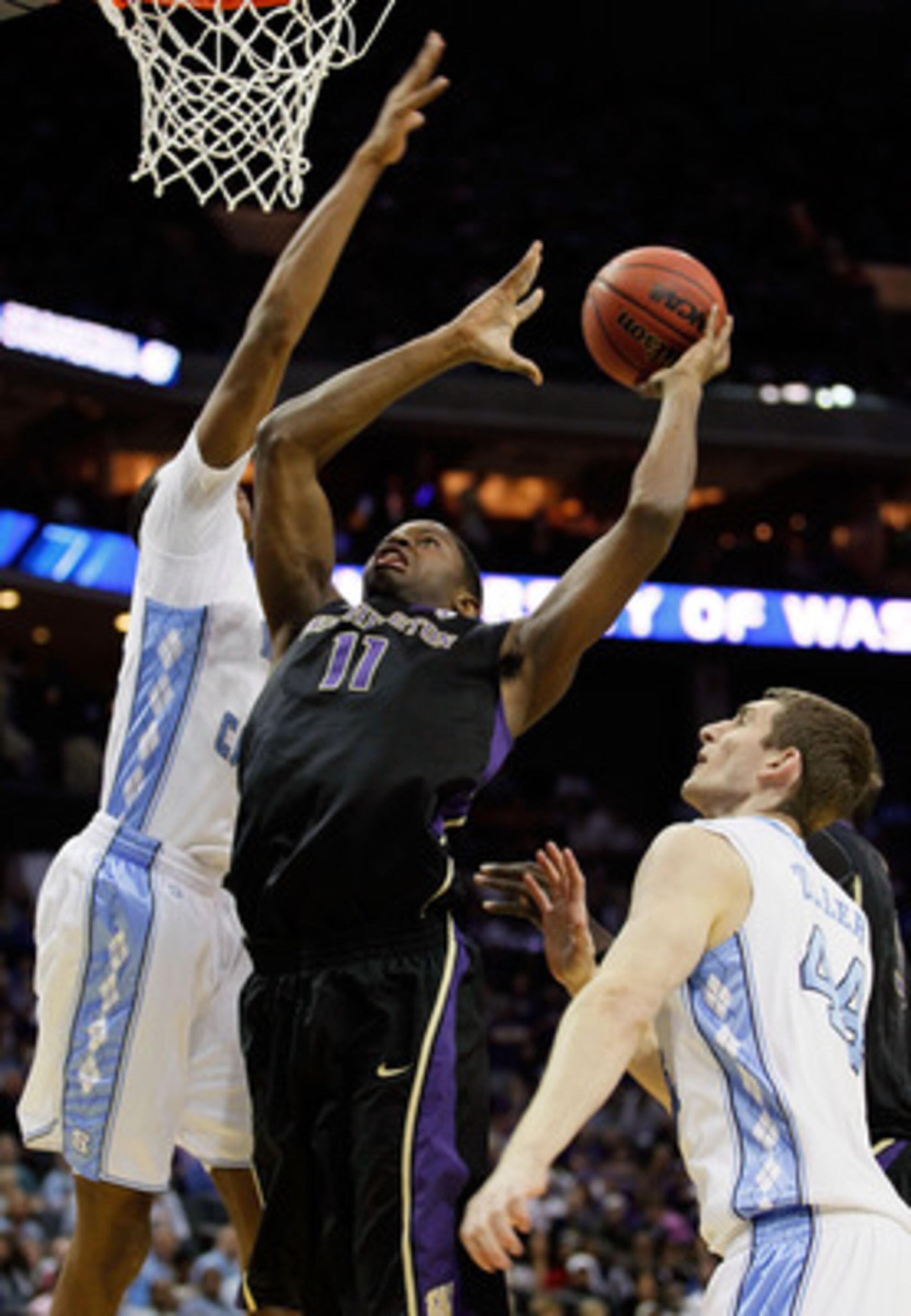 CHARLOTTE, NC - MARCH 20:  Matthew Bryan-Amaning #11 of the Washington Huskies goes up for a shot between John Henson #31 and Tyler Zeller #44 of the North Carolina Tar Heels in the first half during the third round of the 2011 NCAA men's basketball tourn