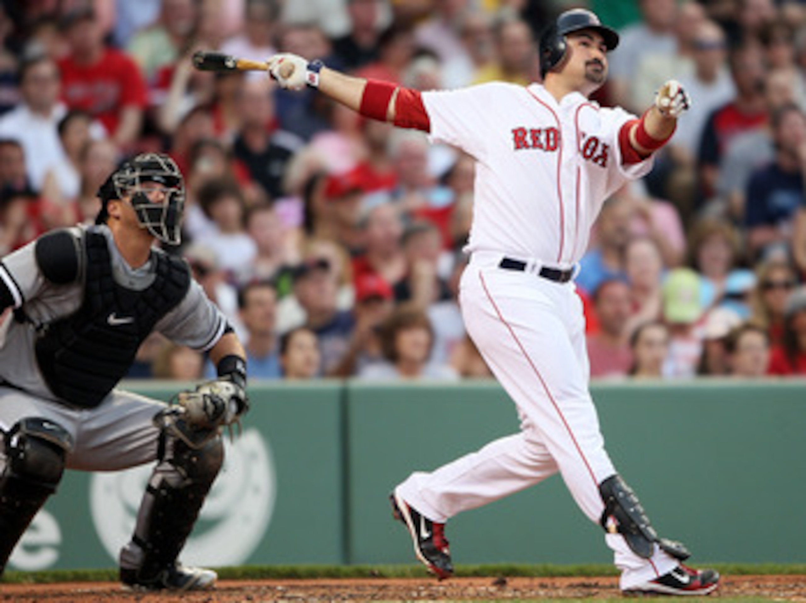 BOSTON, MA - MAY 30:  Adrian Gonzalez #28 of the Boston Red Sox hits a solo home run in the first inning as A.J. Pierzynski #12 of the Chicago White Sox catches on May 30, 2011 at Fenway Park in Boston, Massachusetts.  (Photo by Elsa/Getty Images)