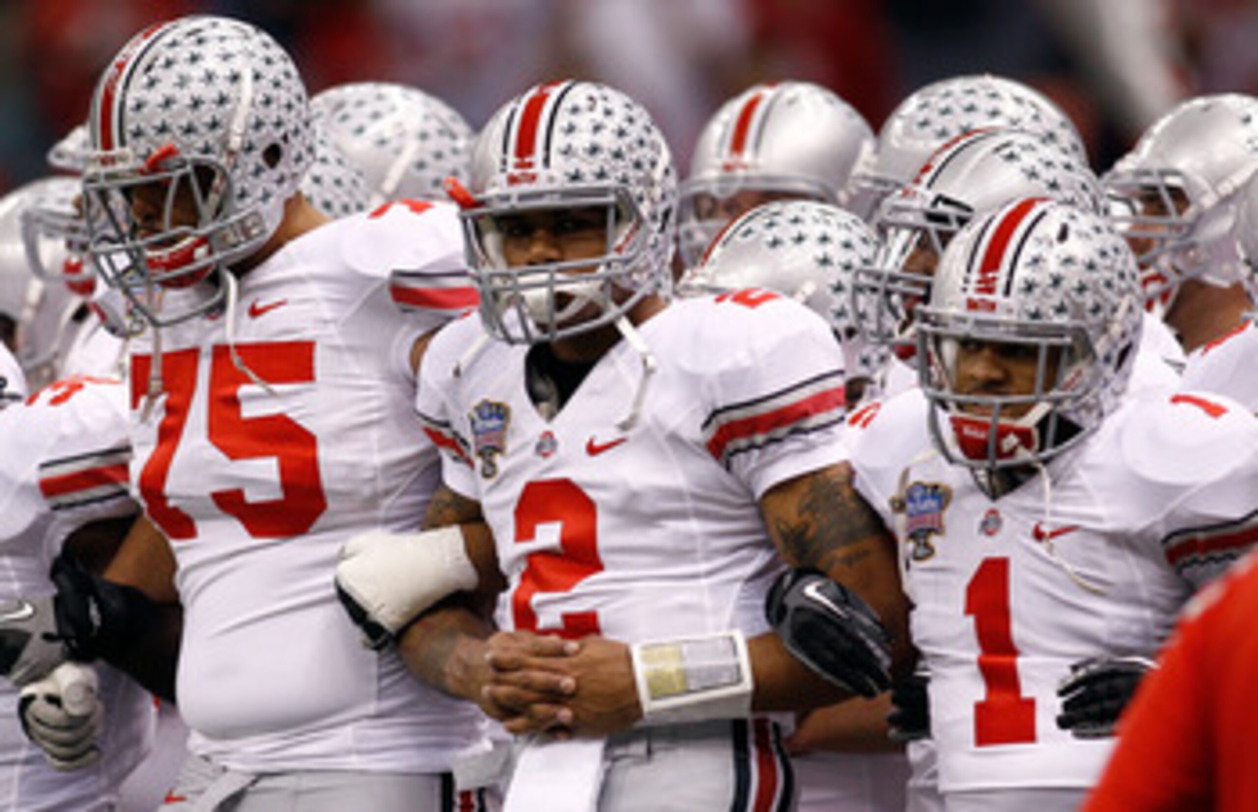 NEW ORLEANS, LA - JANUARY 04:  (R-L) Dan Herron #1, Terrelle Pryor #2 and Mike Adams #75 of the Ohio State Buckeyes gather with teammates before taking on the Arkansas Razorbacks during the Allstate Sugar Bowl at the Louisiana Superdome on January 4, 2011