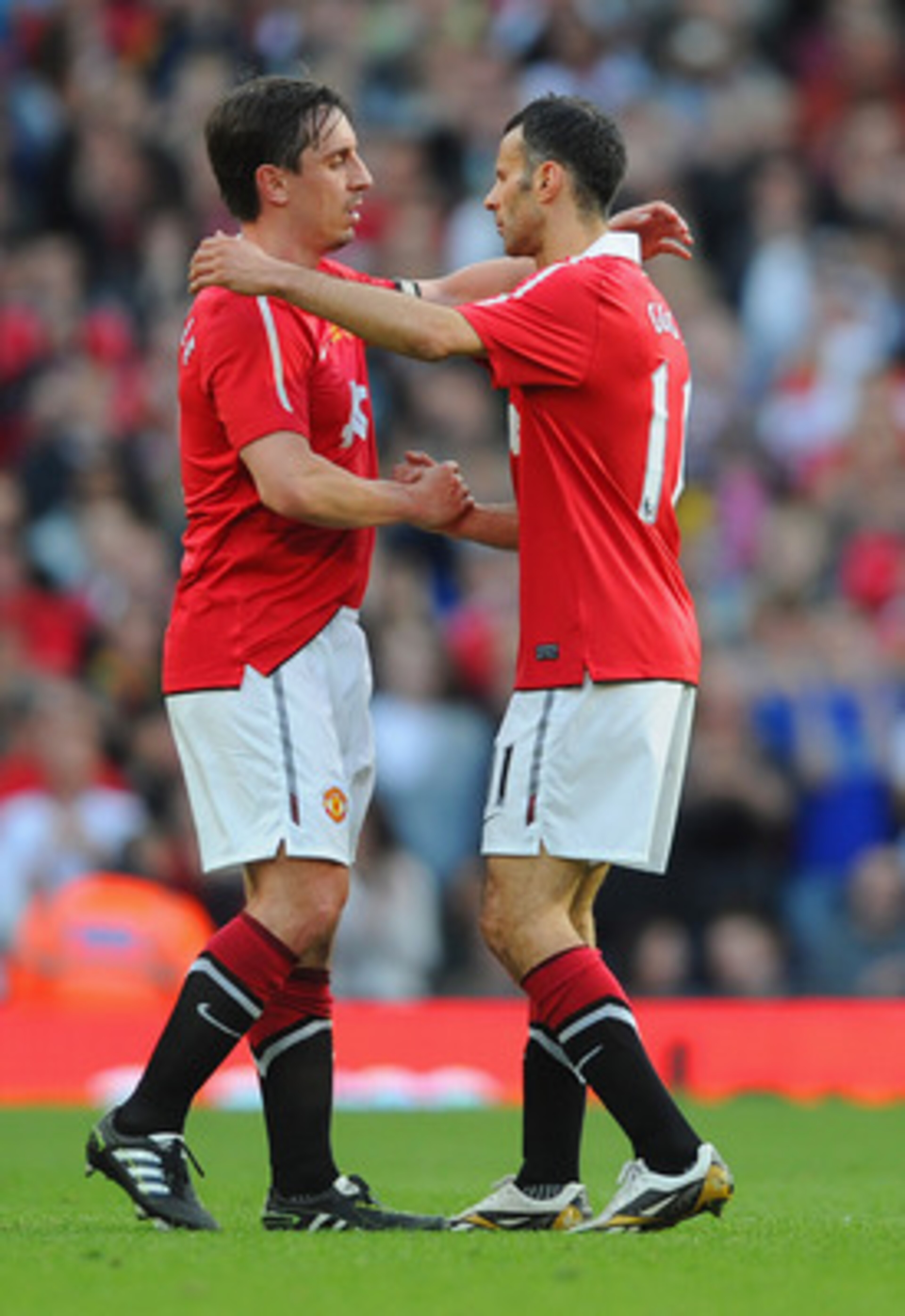 MANCHESTER, ENGLAND - MAY 24:  Ryan Giggs of Manchester United shakes hands with Gary Neville as he is subbed during the Gary Neville Testimonial Match between Manchester United and Juventus at Old Trafford on May 24, 2011 in Manchester, England.  (Photo 