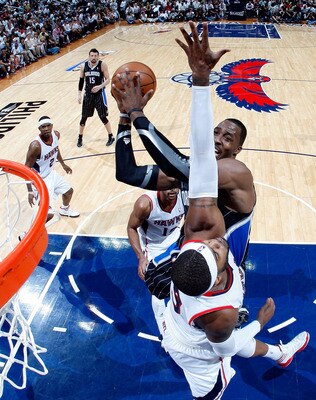ATLANTA, GA - APRIL 24:  Dwight Howard #12 of the Orlando Magic attacks the basket against Josh Smith #5 of the Atlanta Hawks during Game Four of the Eastern Conference Quarterfinals in the 2011 NBA Playoffs at Philips Arena on April 24, 2011 in Atlanta, 