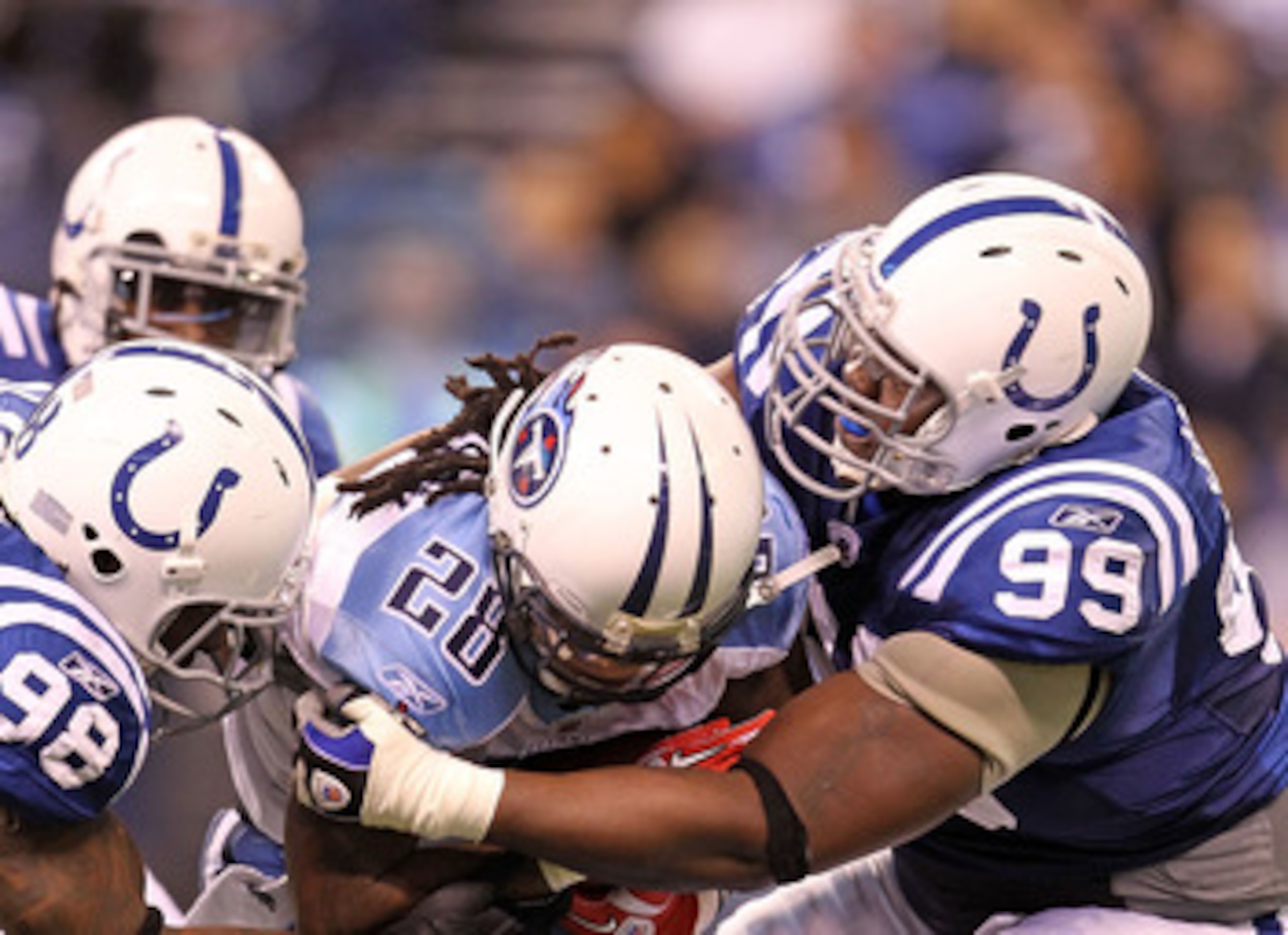 INDIANAPOLIS - JANUARY 02:  Chris Johnson #28 of the Tennessee Titans is tackled by Robert Mathis #98 and Antonio Johnson #99 of the Indianapolis Colts at Lucas Oil Stadium on January 2, 2011 in Indianapolis, Indiana.  the Colts won 23-20.  (Photo by Andy
