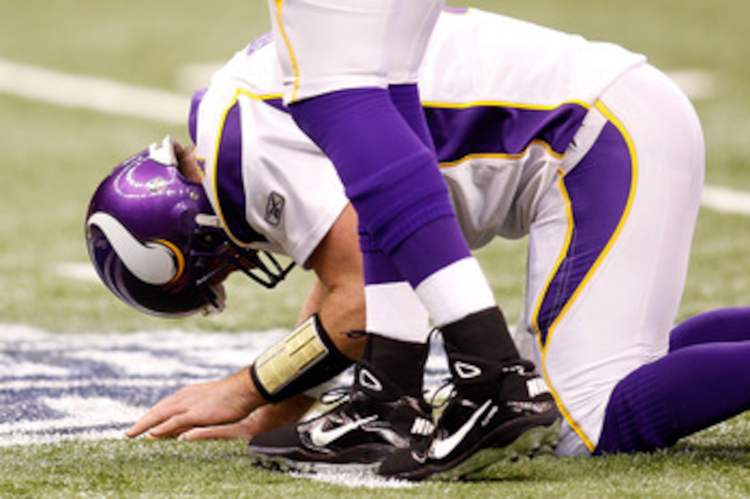 NEW ORLEANS - JANUARY 24:  Quarterback Brett Favre #4 of the Minnesota Vikings kneels on the turf in pain after he took a hard hit against the New Orleans Saints during the NFC Championship Game at the Louisiana Superdome on January 24, 2010 in New Orlean