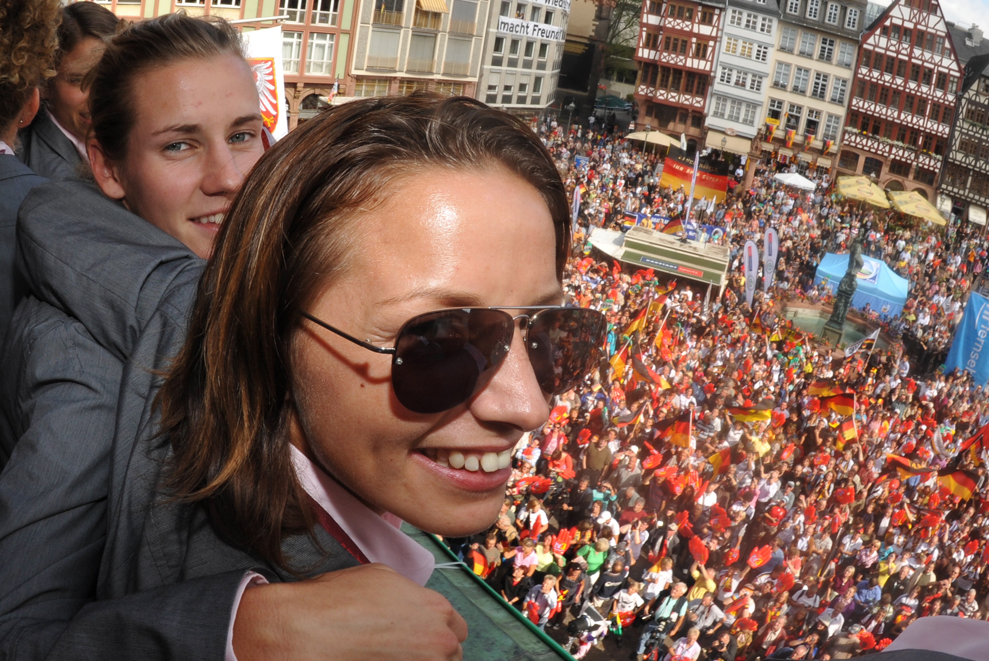 FRANKFURT AM MAIN, GERMANY - SEPTEMBER 11: (L-R) Simone Laudehr and Inka Grings celebrate during a reception for the German women's national team on the balcony of the city hall 'Roemer' on September 11, 2009 in Frankfurt am Main, Germany.  (Photo by Bori