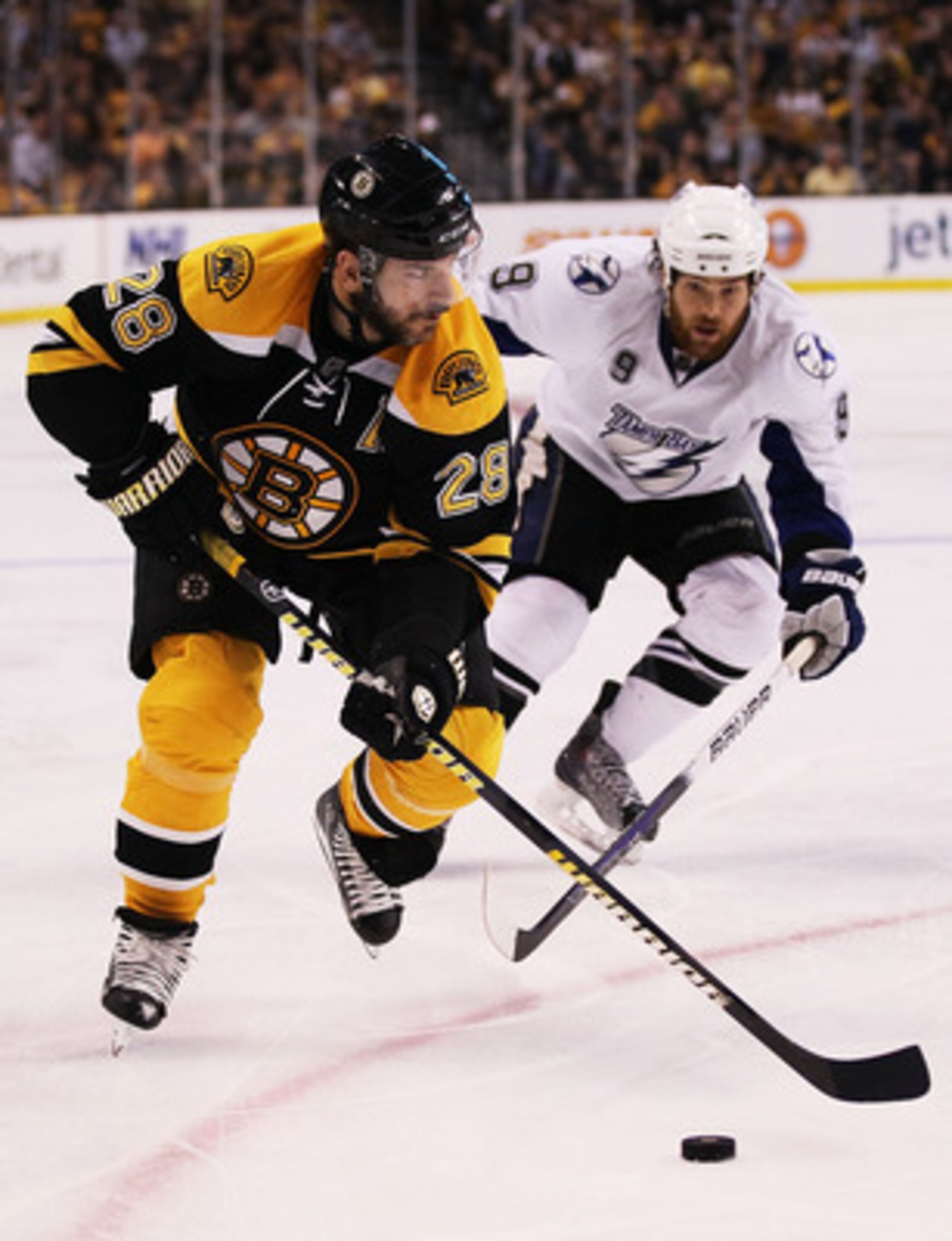 BOSTON, MA - MAY 27:  Mark Recchi #28 of the Boston Bruins and Steve Downie #9 of the Tampa Bay Lightning vie for the puck in Game Seven of the Eastern Conference Finals during the 2011 NHL Stanley Cup Playoffs at TD Garden on May 27, 2011 in Boston, Mass