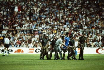 Patrick Battiston of France is carried off the field on a stretcher badly injured with a damaged vertebrae, a broken jaw and the loss of four of his front teeth after a contentious collision with goalkeeper Harald Schumacher of the Federal Republic of Ger